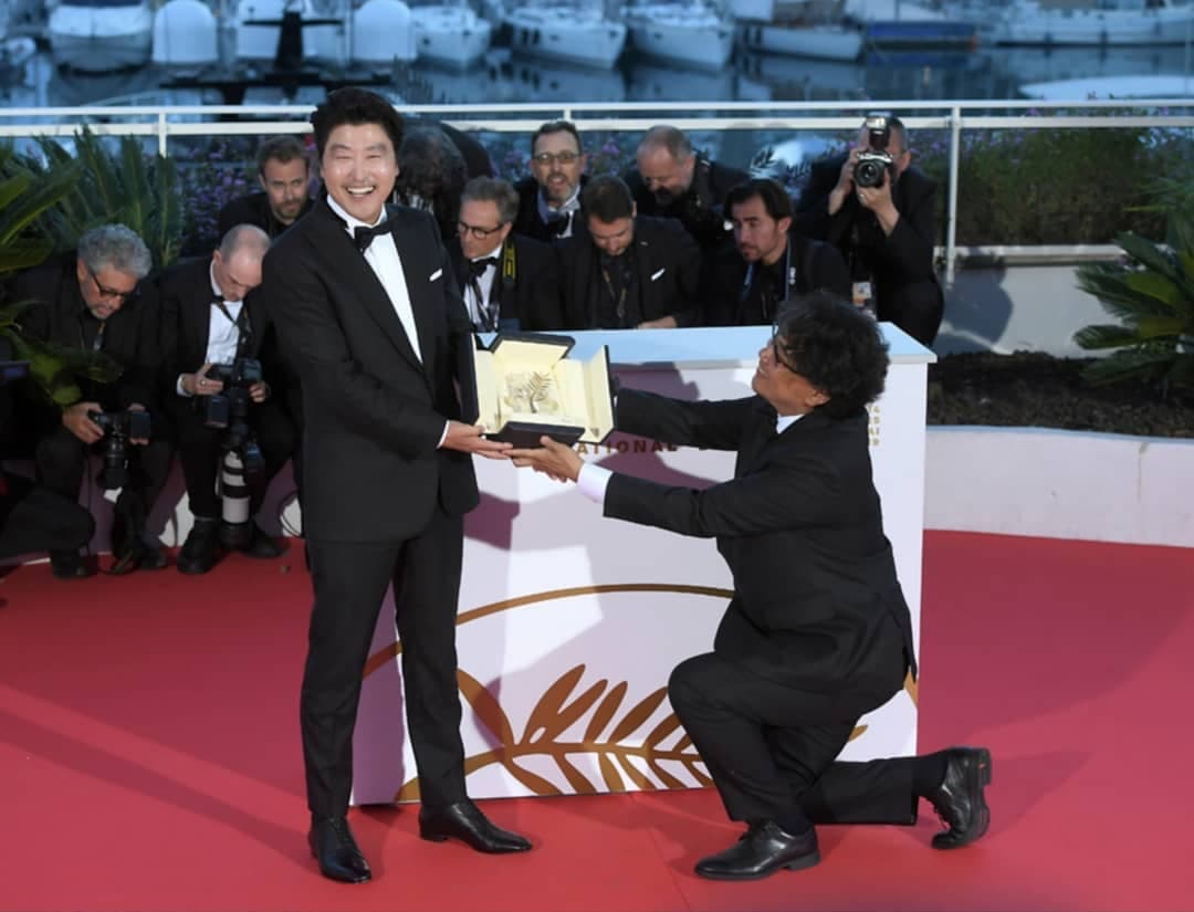 《寄生上流》拿到坎城金棕櫚獎,導演單膝下跪將獎項獻給宋康昊。(翻攝自cjen娛樂ig)