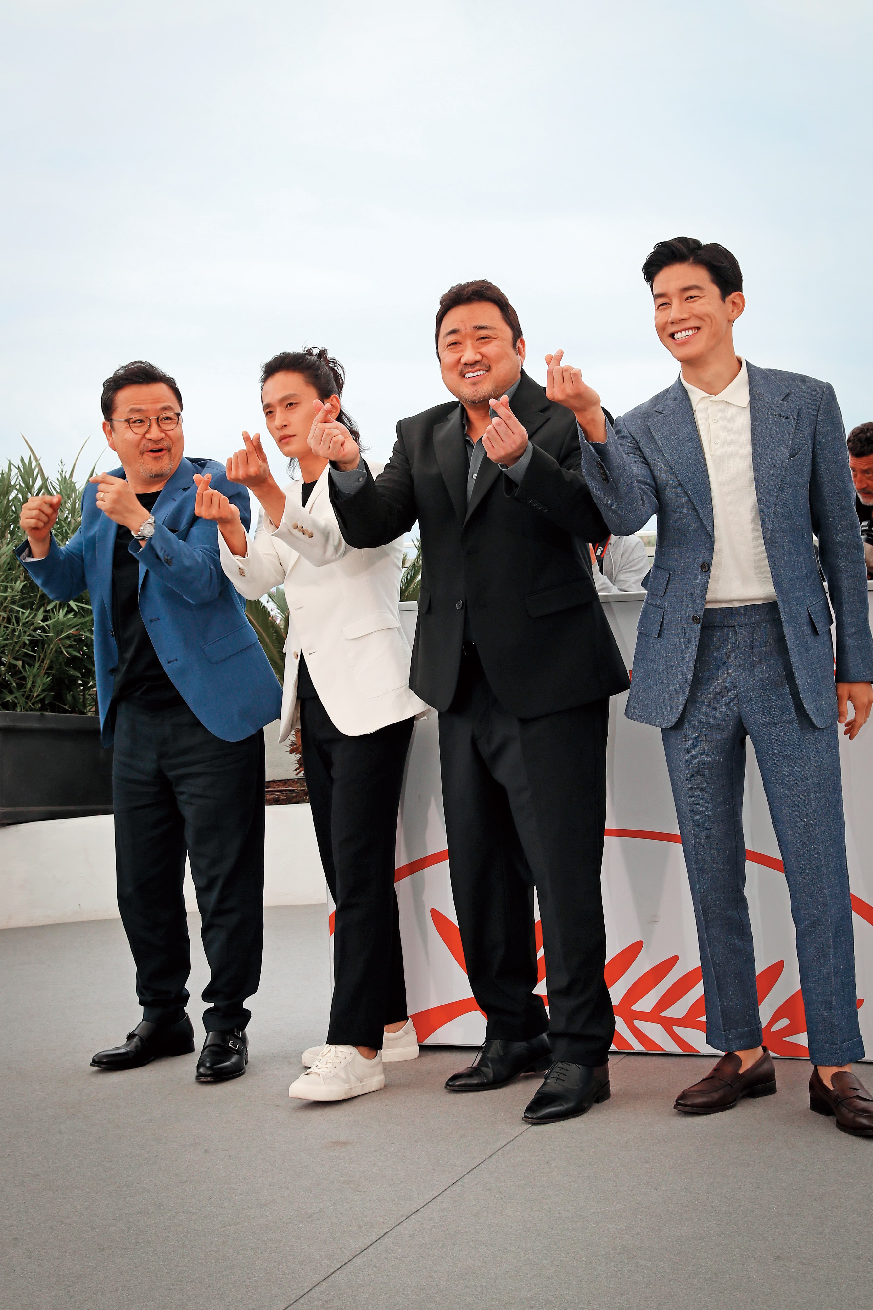  《極惡對決》在本屆坎城影展午夜放映單元受到觀眾歡迎，導演李元泰（左起）率演員金成圭、馬東石與金武烈比手指愛心。（東方IC）