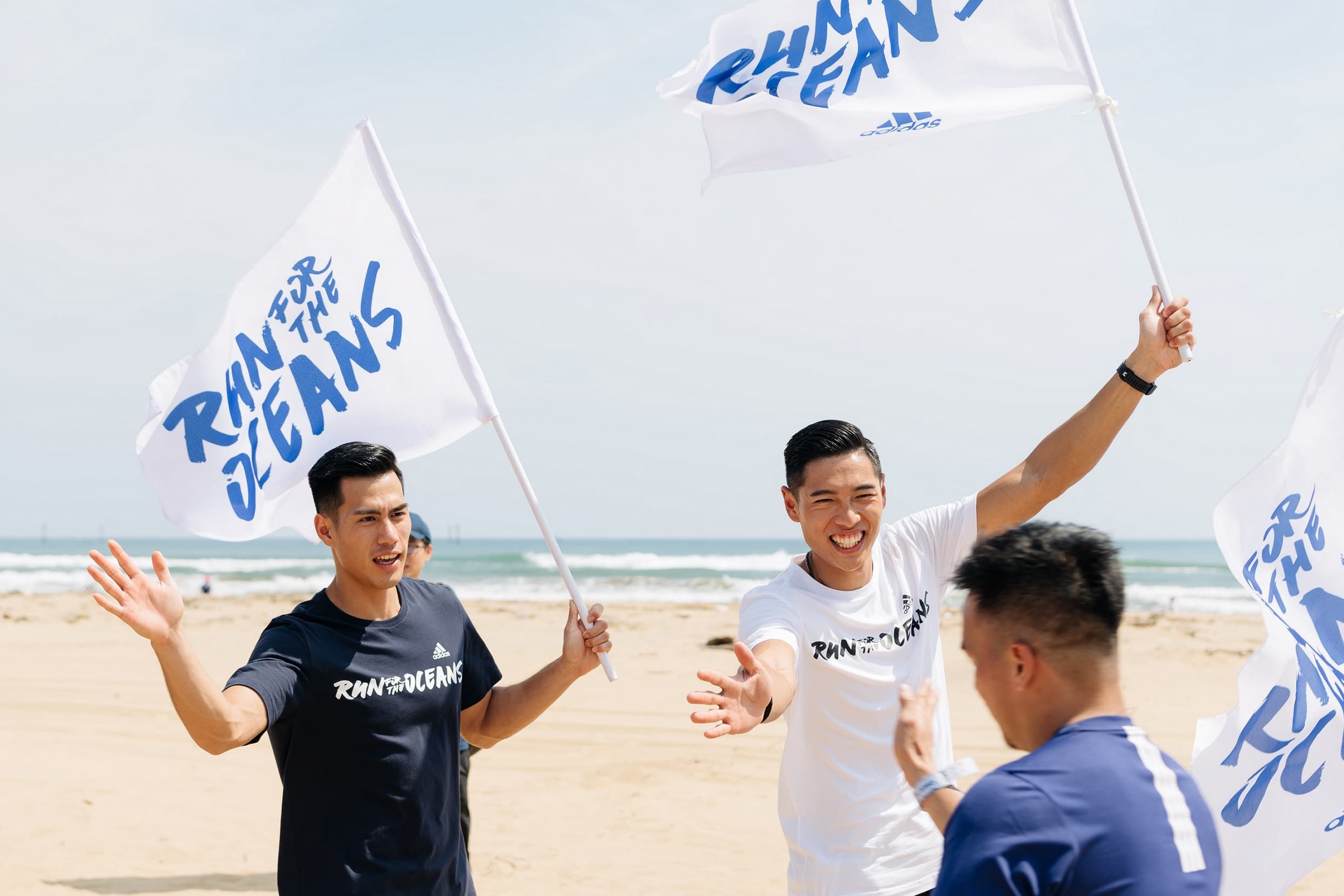 楊俊瀚（左）、陳傑在路跑終點，跟跑者擊掌加油打氣。（adidas提供）