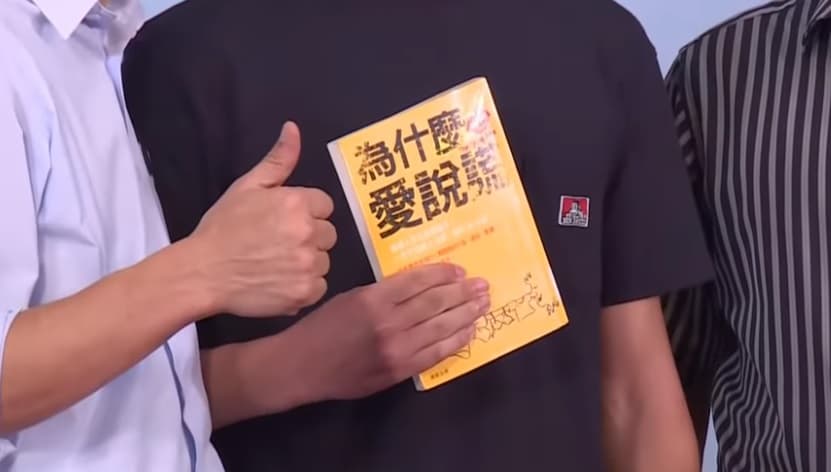 一名雄中學生在與韓國瑜合照時，亮出一本《為什麼愛說謊》書籍，引人聯想。（翻攝自YouTube：台視新聞 TTV NEWS）