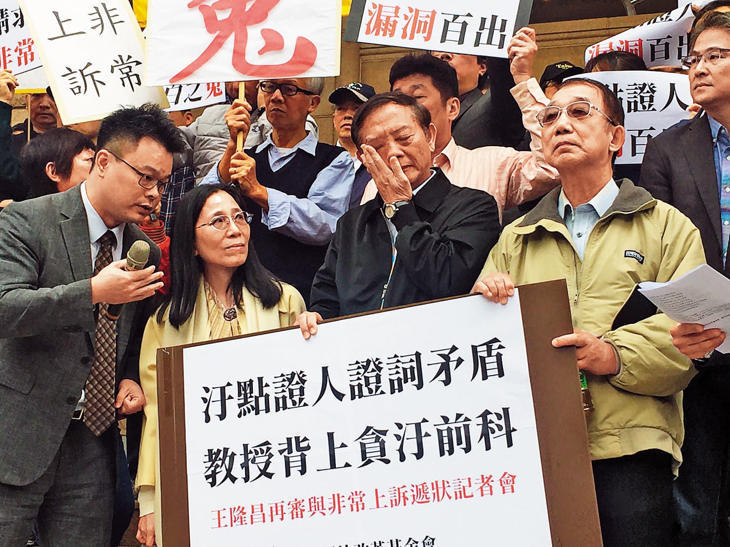 今年2月，王隆昌（右2）在司改會林俊宏（左1）律師、前大法官許玉秀（左2），及許多教授、學生陪同下，到最高檢察署遞狀喊冤，請求檢察總長提起非常上訴。（聯合知識庫）