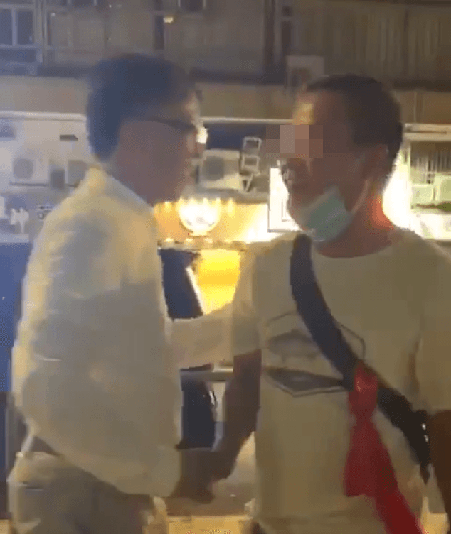 議員何君堯與其中一名白衣人握手，還拍肩表示鼓勵。（翻攝自網路影片）