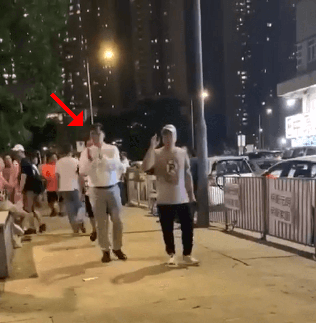 議員何君堯向白衣人走去，一路拍拍手。（翻攝自網路影片）