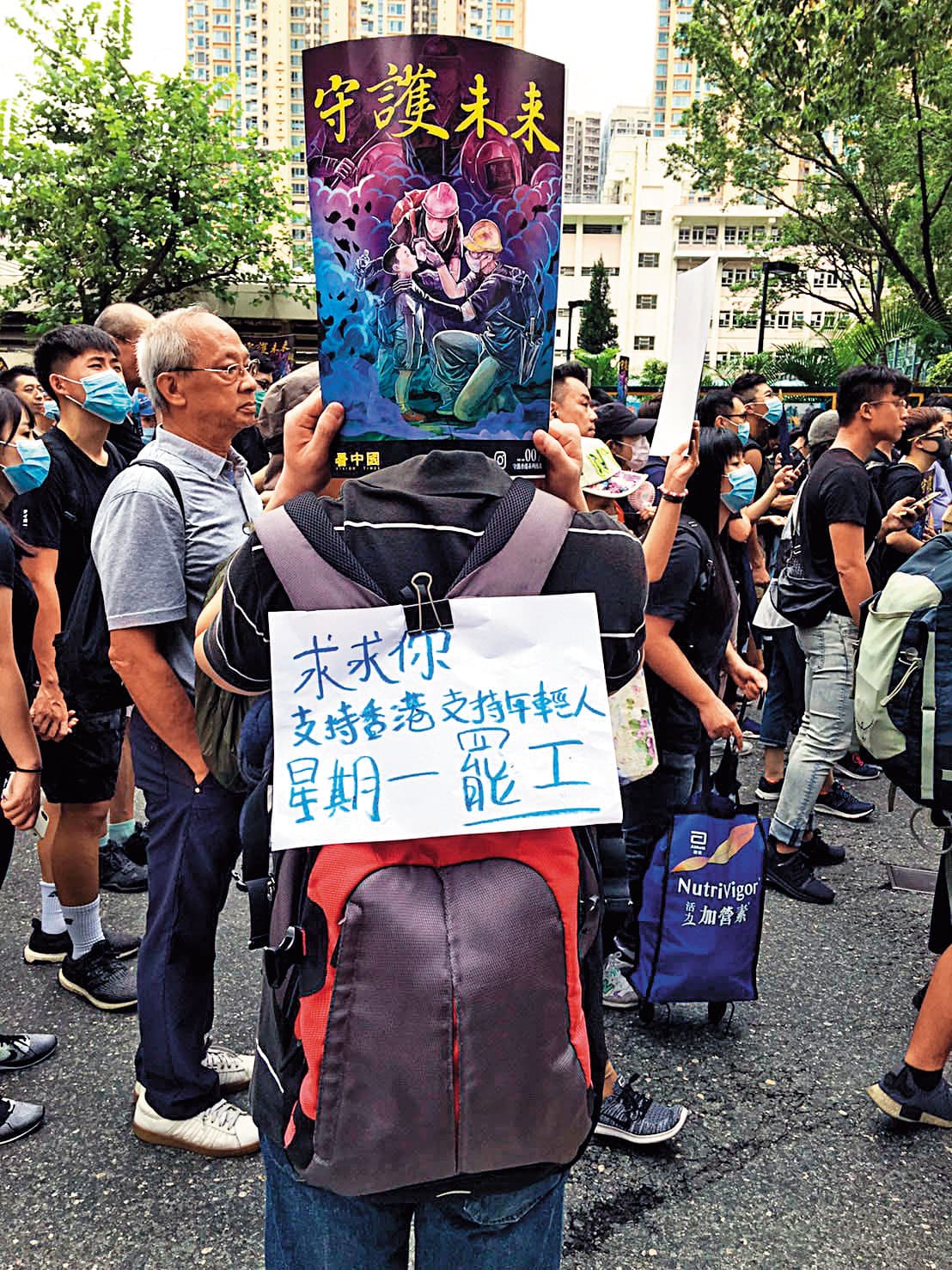 律師阿輝參與遊行，在身上貼「求求你，星期一罷工」字條，談到台灣時，冷靜的他落下熱淚。