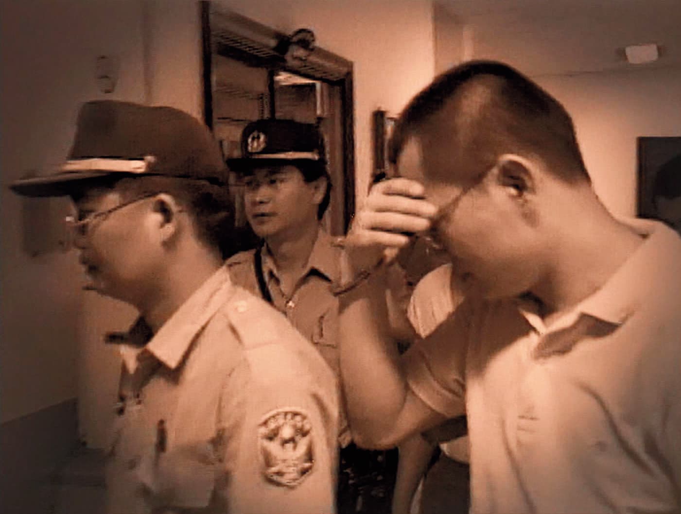 殺人棄屍的共犯鄭連金(右)被逮捕時,以手遮臉,深怕面容曝光。(東森新聞提供)
