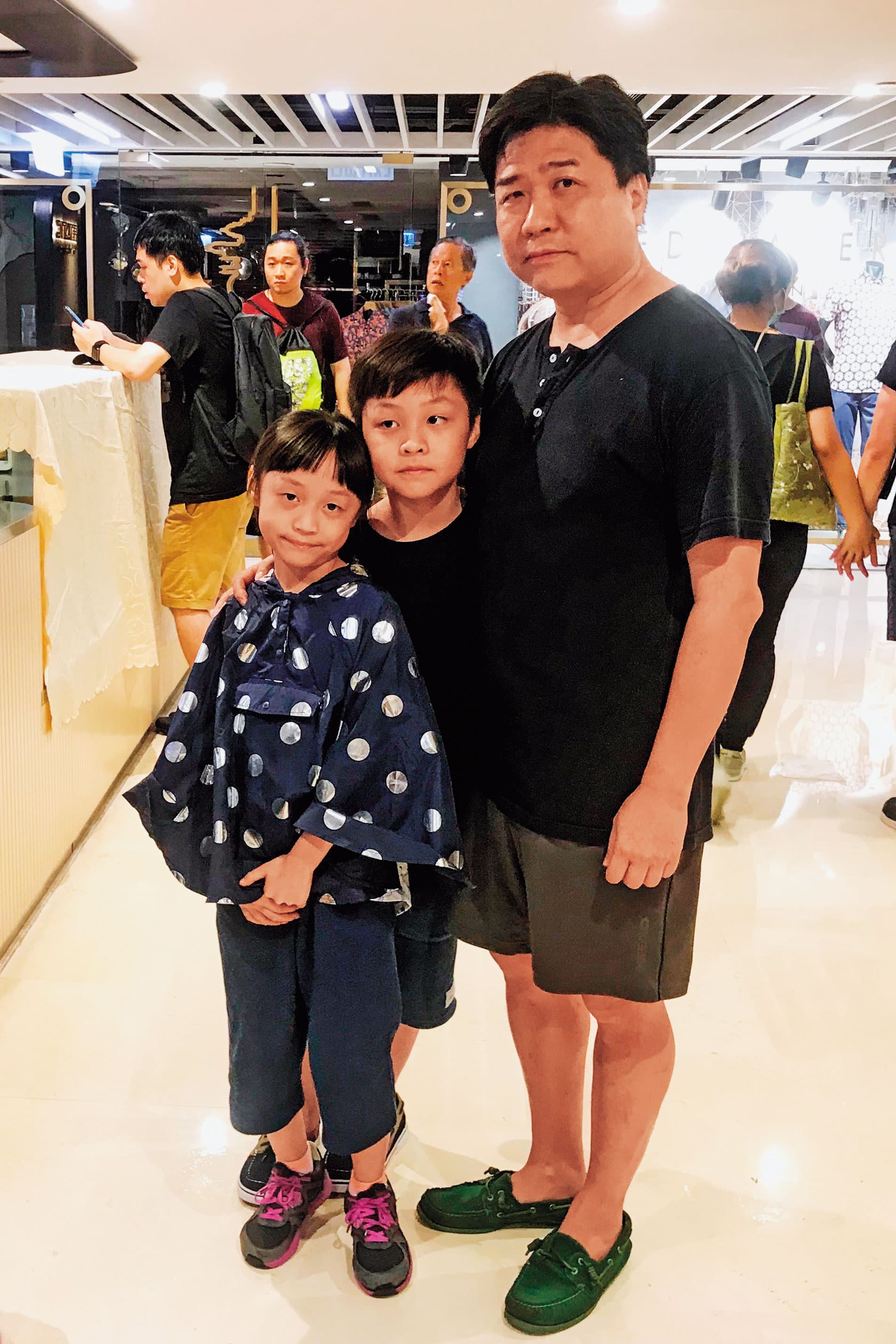 49歲的吳丹尼（化名）與參加遊行的一對兒女。