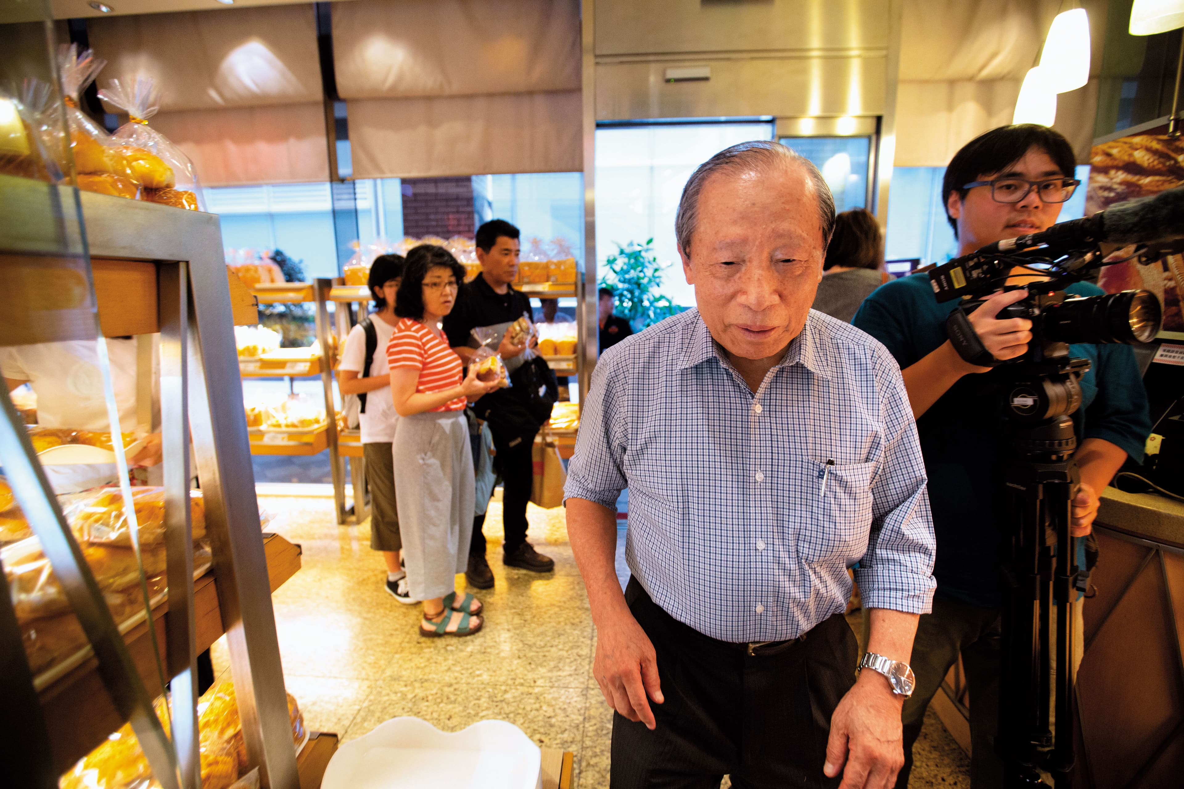 洪騰勝（右2）不愛拍照，他在飯店內巡視，一見到鏡頭便匆匆閃避。