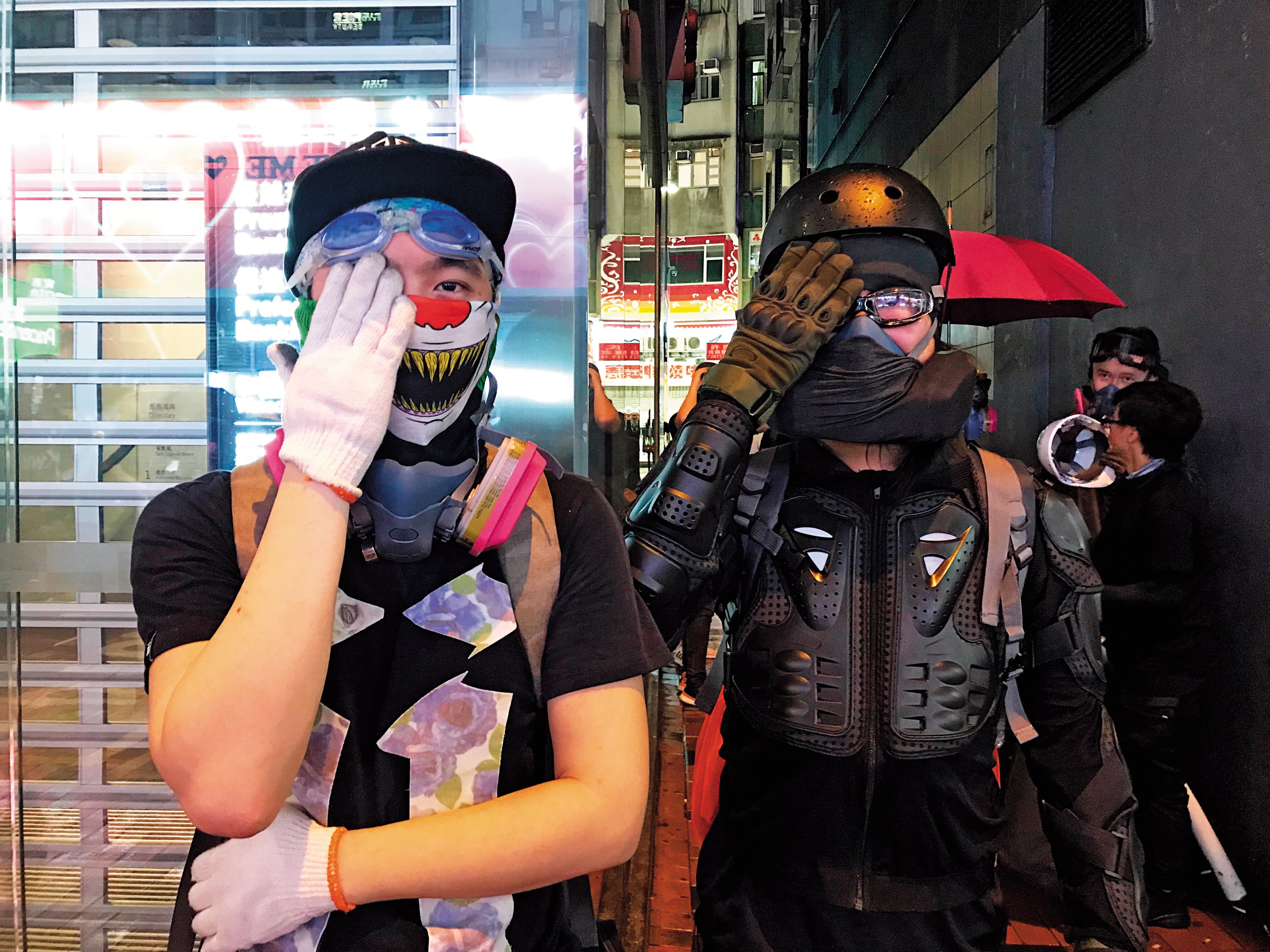 2名勇武派示威者遮住右眼,諷刺警方射傷香港民眾眼睛。(陳虹瑾攝)