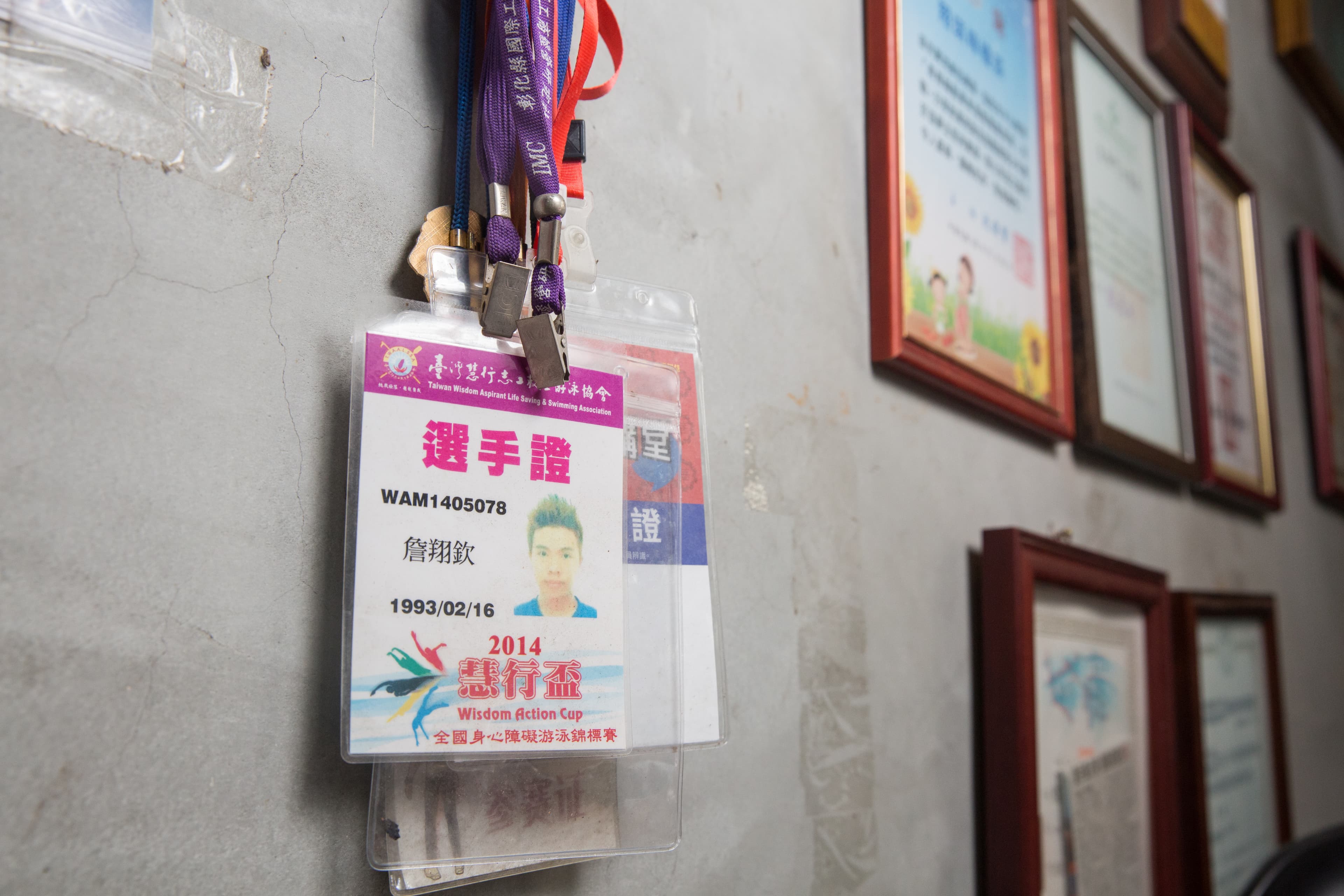牆上掛著詹翔欽參加游泳比賽的選手牌，他是新竹教育大學體育系畢業的游泳健將，還有救生員、急救員等多張證照。