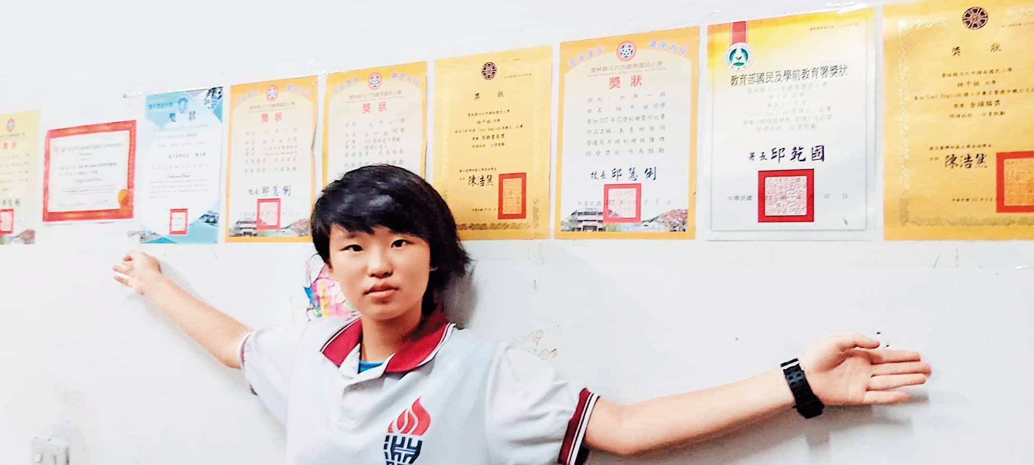 林峻巃家中牆上,貼有多張女兒的英文測驗獎狀。(林峻巃提供)