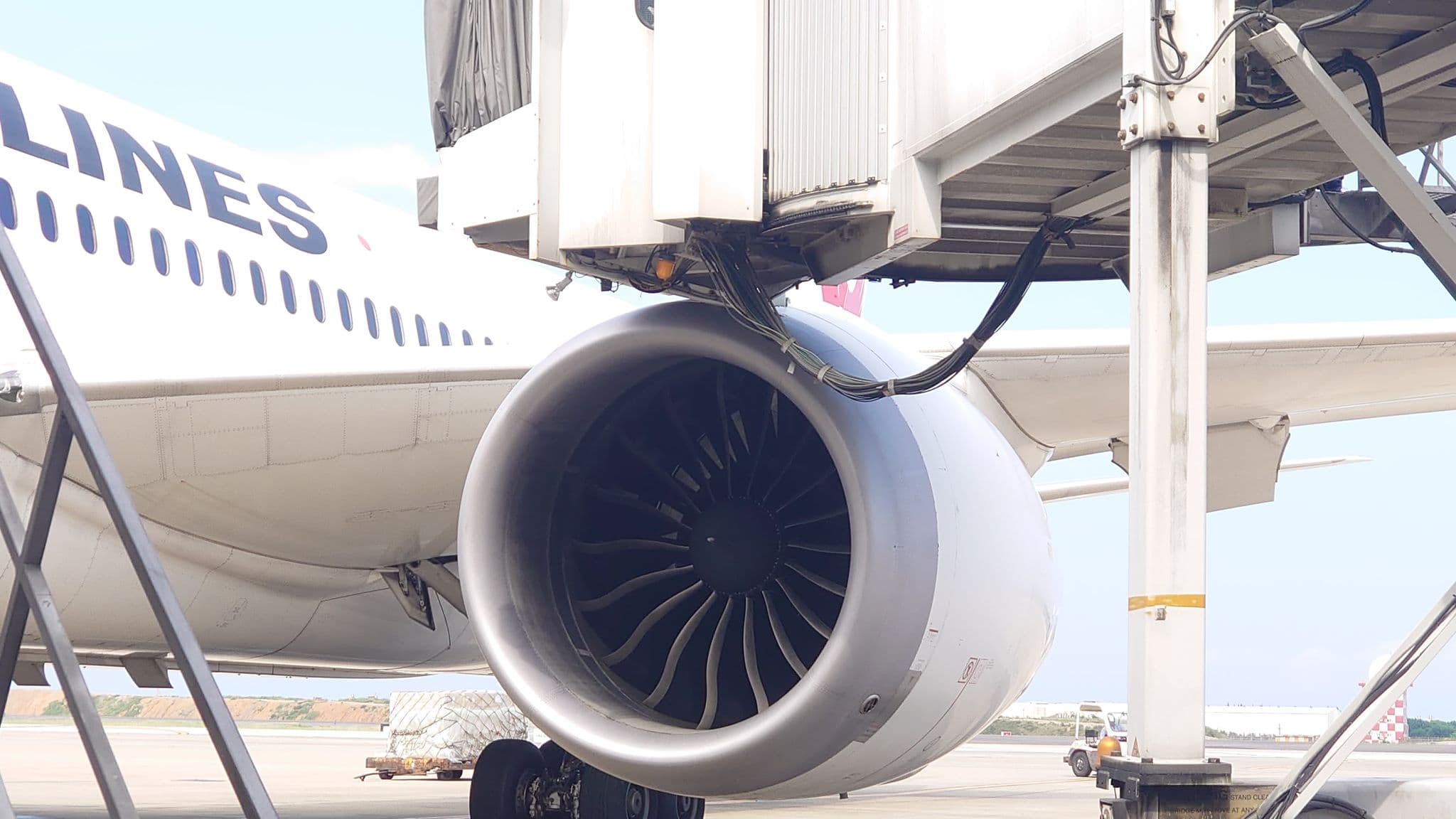 桃機地勤拖車駕駛操作不當,日航飛機機體左側發動機整流罩不慎擦撞空橋。(圖/旅客提供)