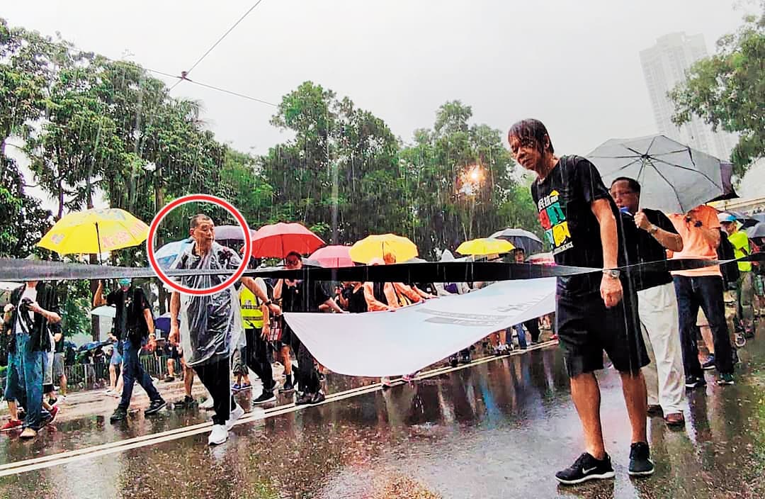 今年8月18日,港人冒雨上街遊行,黎智英(紅圈處)與前立法會議員梁國雄(右)走在隊頭。(翻攝梁國雄臉書)