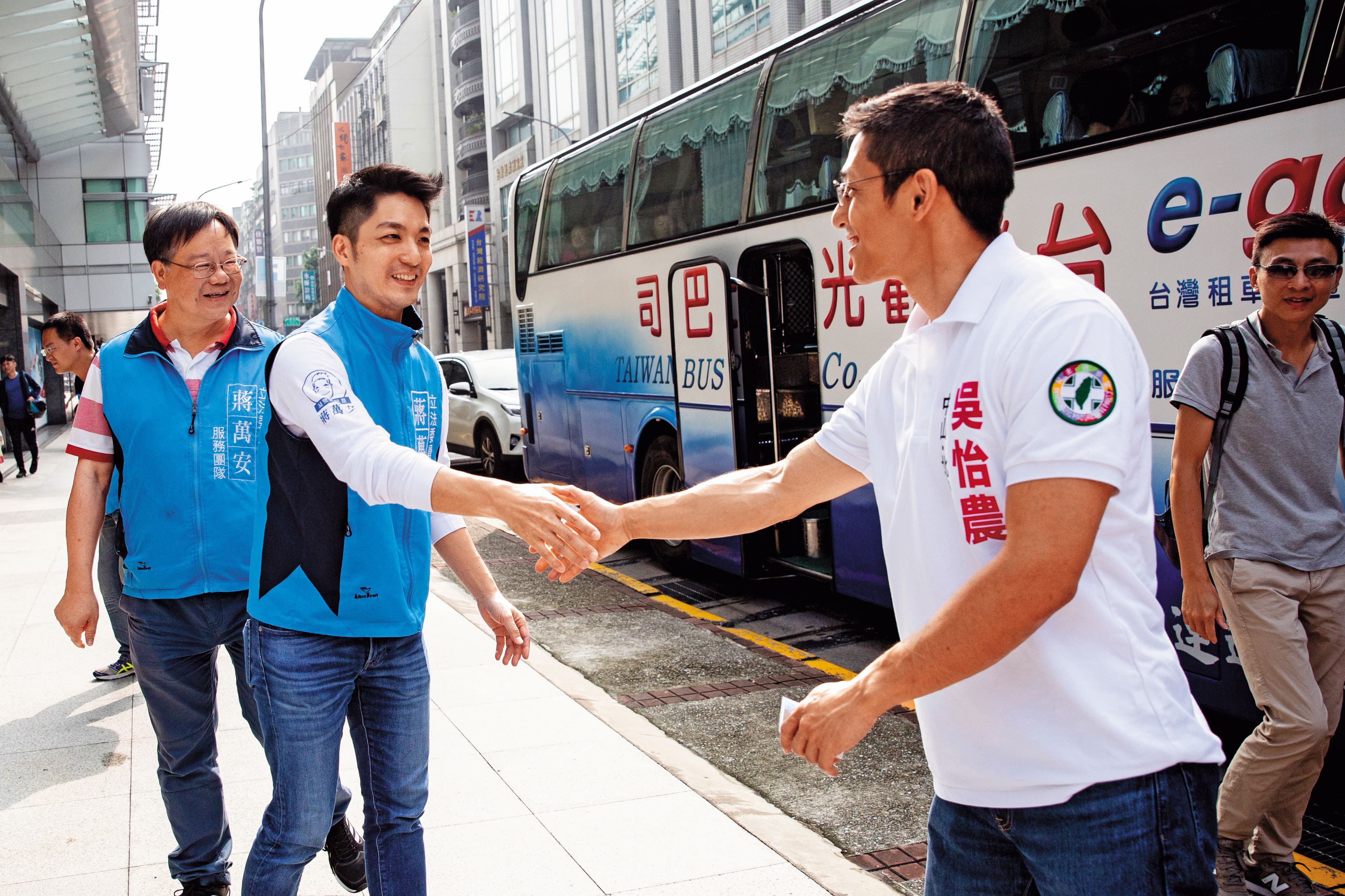 這場被稱「雙帥對決」的選舉,吳怡農(右1)與蔣萬安(右2)都勤拜票,2人經常在早上里民出遊的遊覽車前相遇。