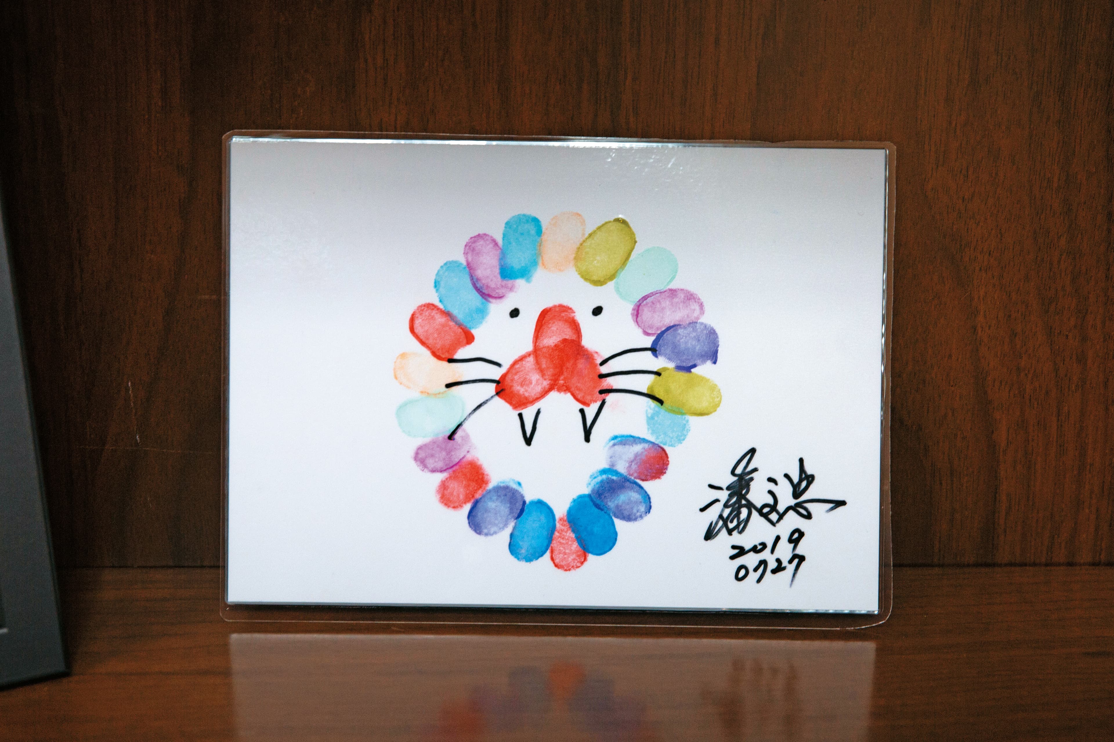 潘文忠的辦公室東西不多,但今年7月在內湖高工活動中製作的手印畫,他珍而重之地展示在辦公室裡。(教育部提供)