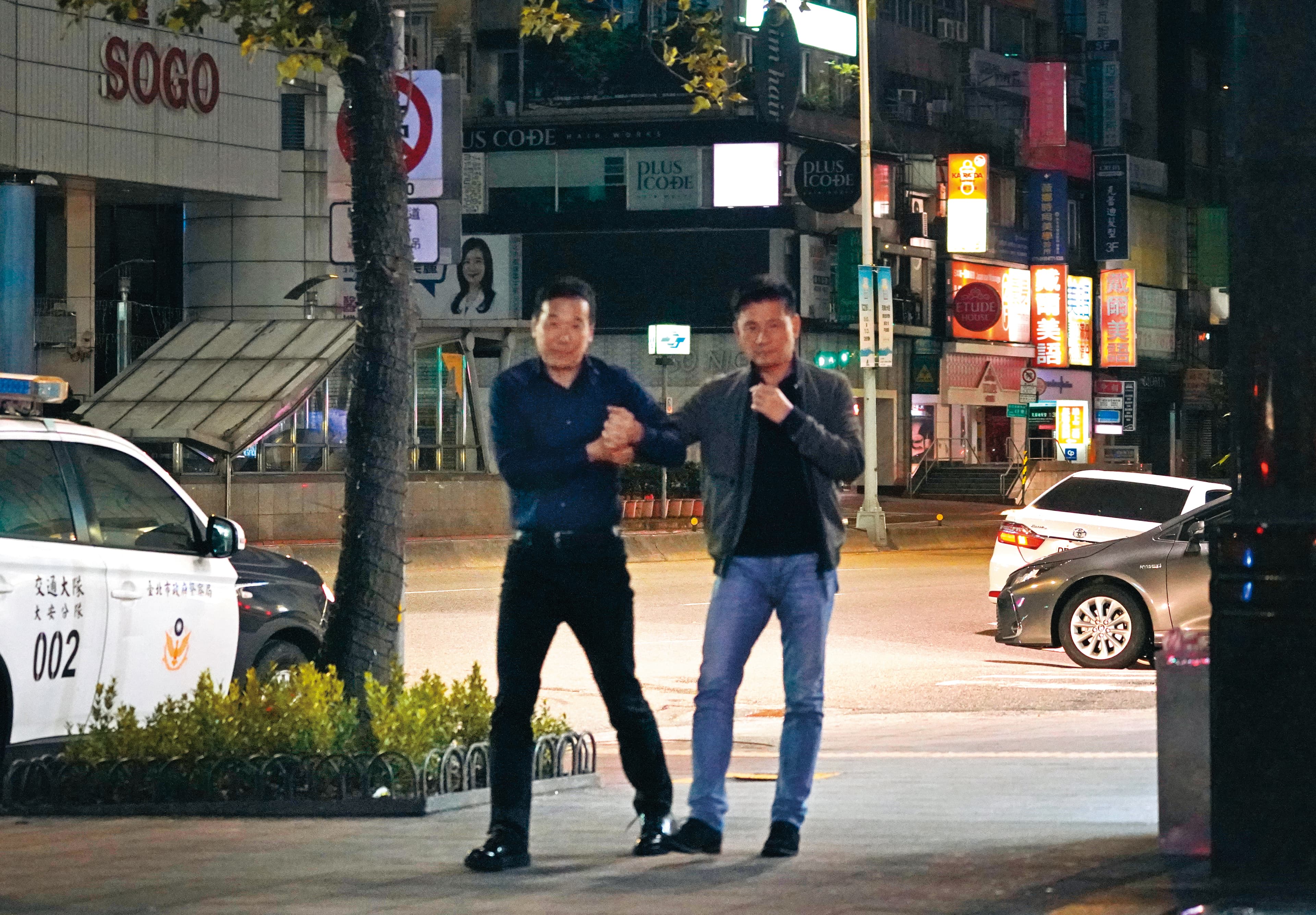 11/28 03：03，鍾小平（左）扶著醉漢戴錫欽從錢櫃走出，並在路上招計程車。