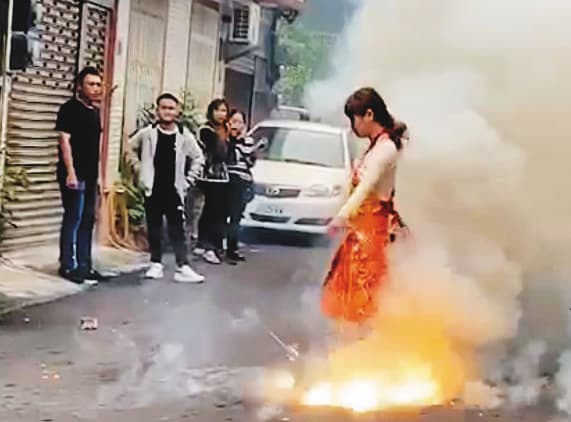 正妹乩童因三太子降駕附身,就算站在鞭炮中也能毫髮無傷。(翻攝臉書)