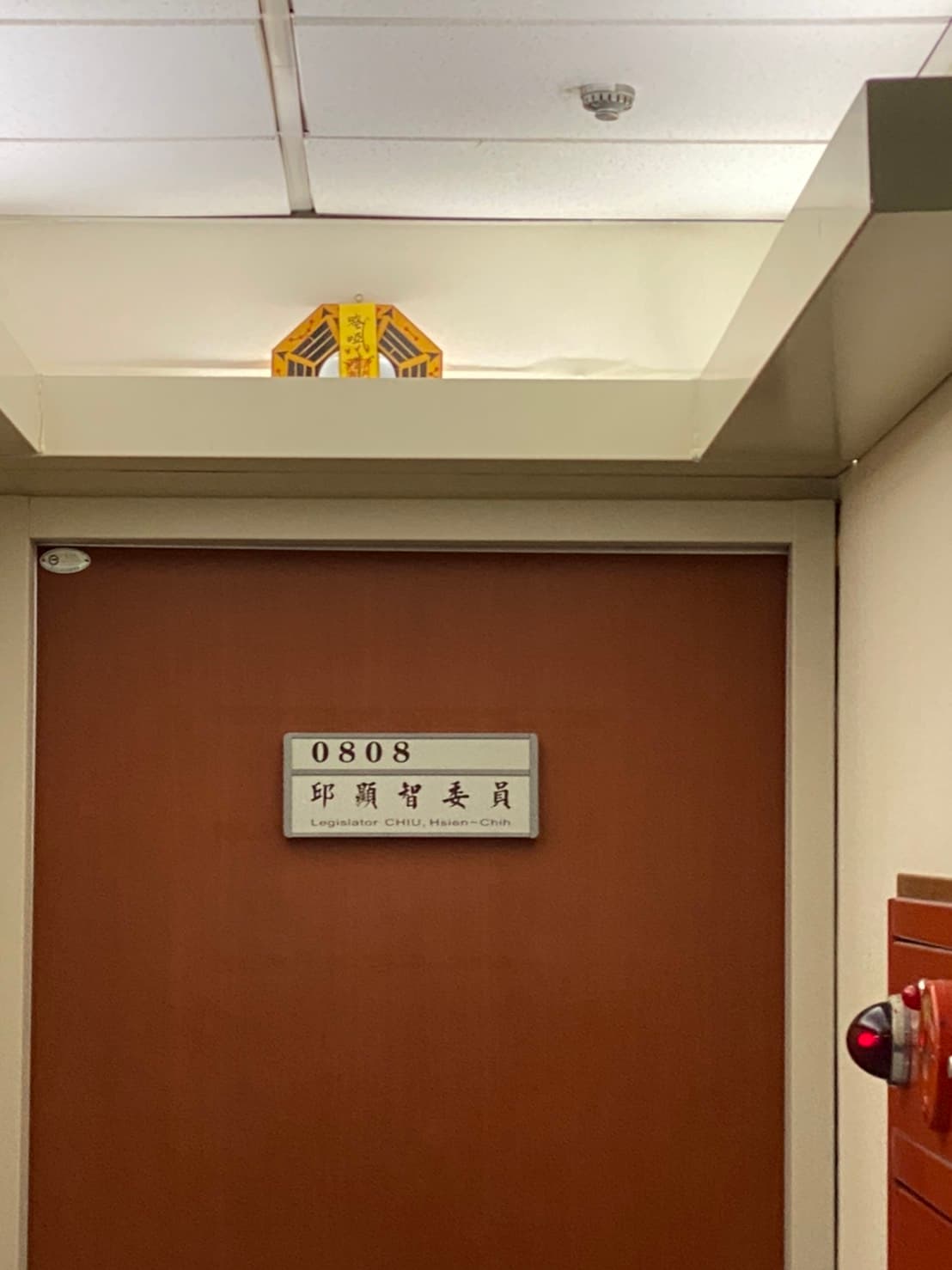 時代力量立委邱顯智研究室門上懸掛一面貼了符咒的八卦鏡。