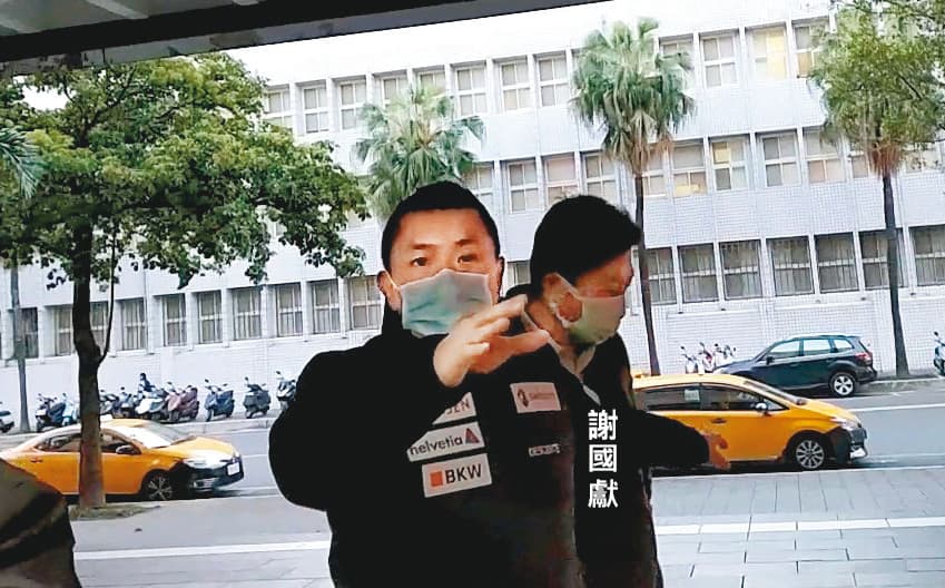 謝國獻移送北檢複訊時，承辦員警一看到記者，即出手擋鏡頭。