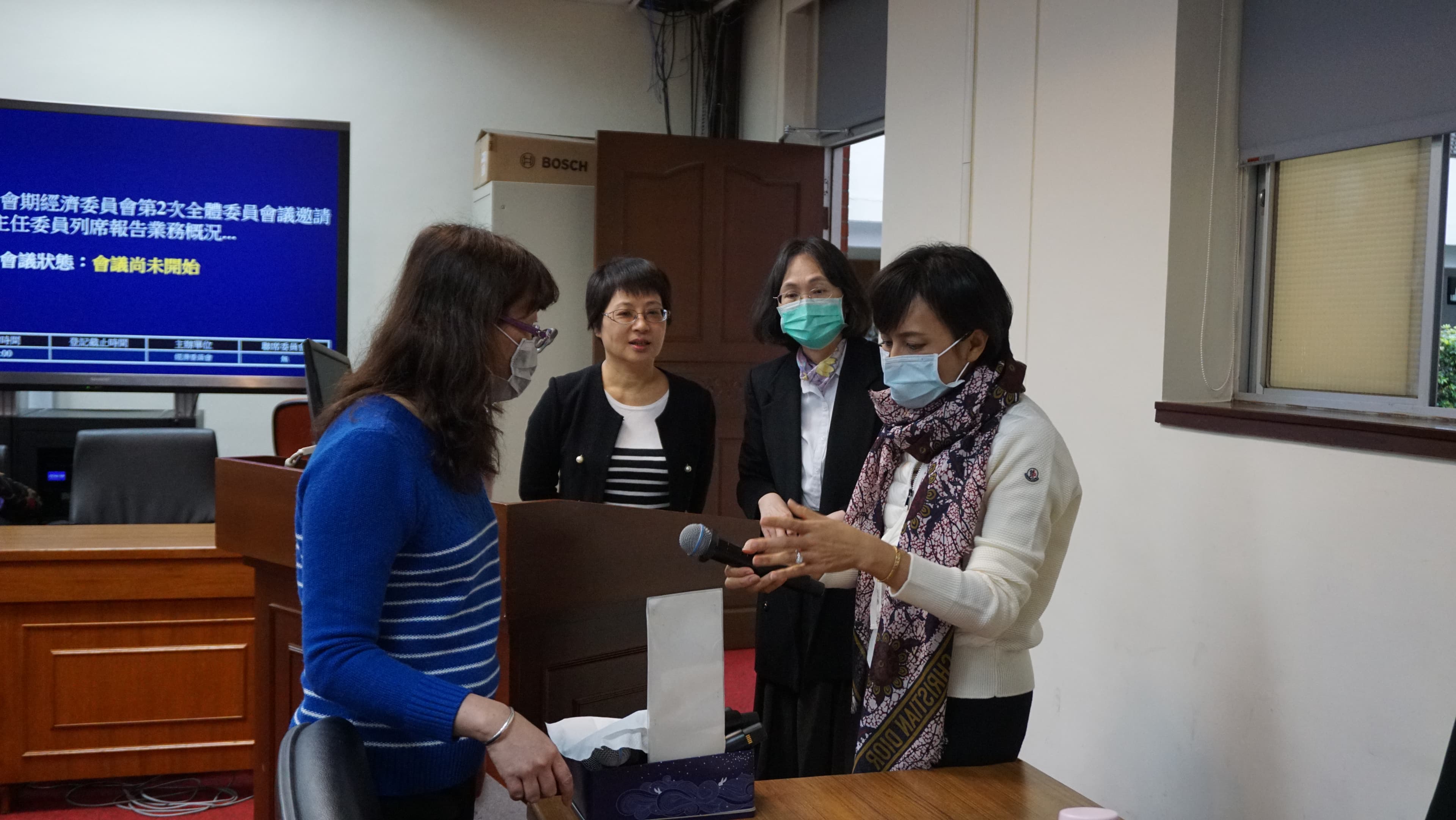 經濟委員會召委邱議瑩和議事人員確認無線麥克風消毒狀況。(邱議瑩辦公室提供)