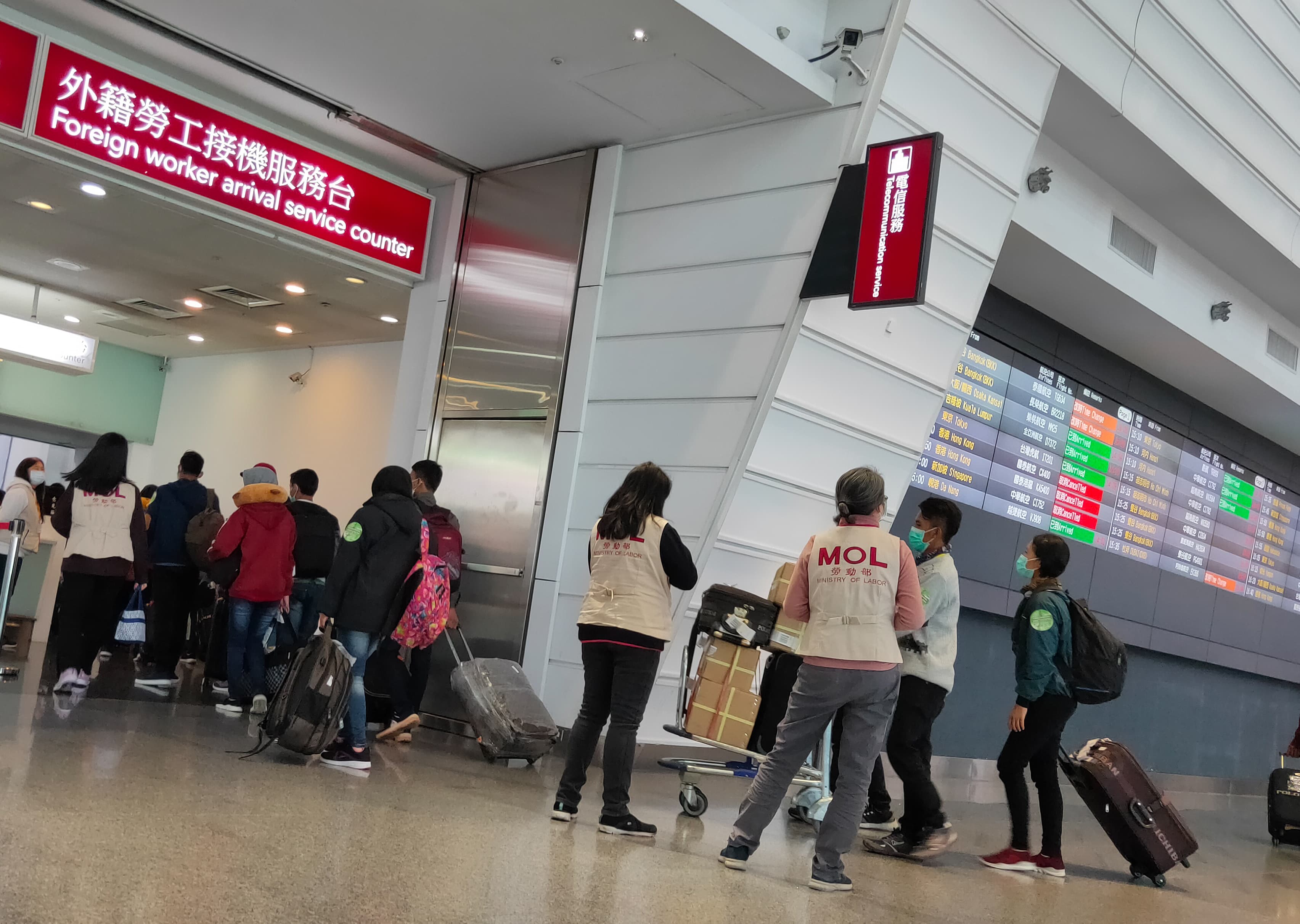 本刊直擊移工抵台後,身穿寫有「MOL」背心的勞動部人員將他們帶到外籍勞工接機服務台,進行講習宣導。