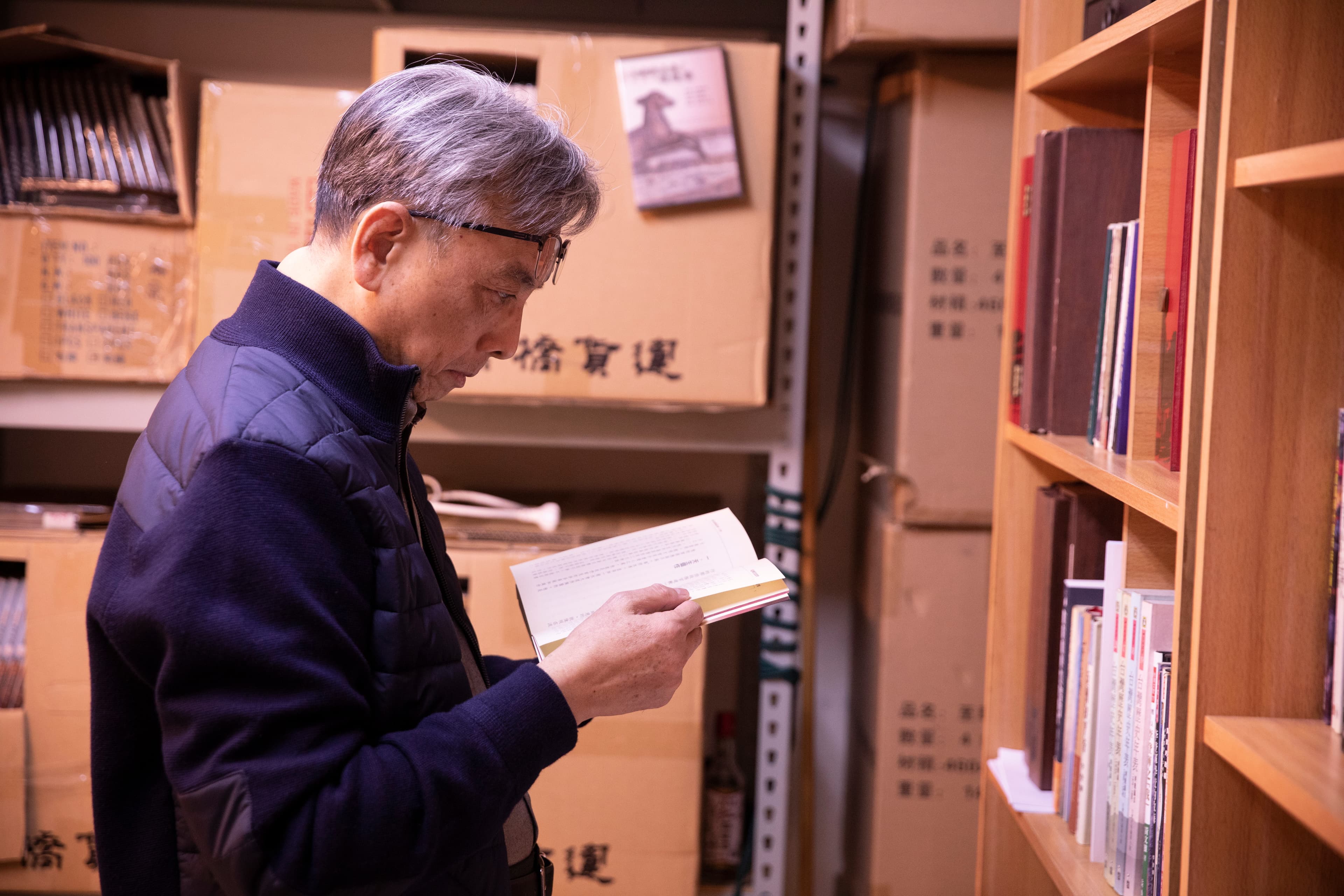 蘇志誠閱讀量大，當年的總統府內，他的辦公桌上堆放最多的書是佛學和哲學書籍。圖為蘇志誠在《國際橋牌社》劇組翻閱李登輝的相關著作。