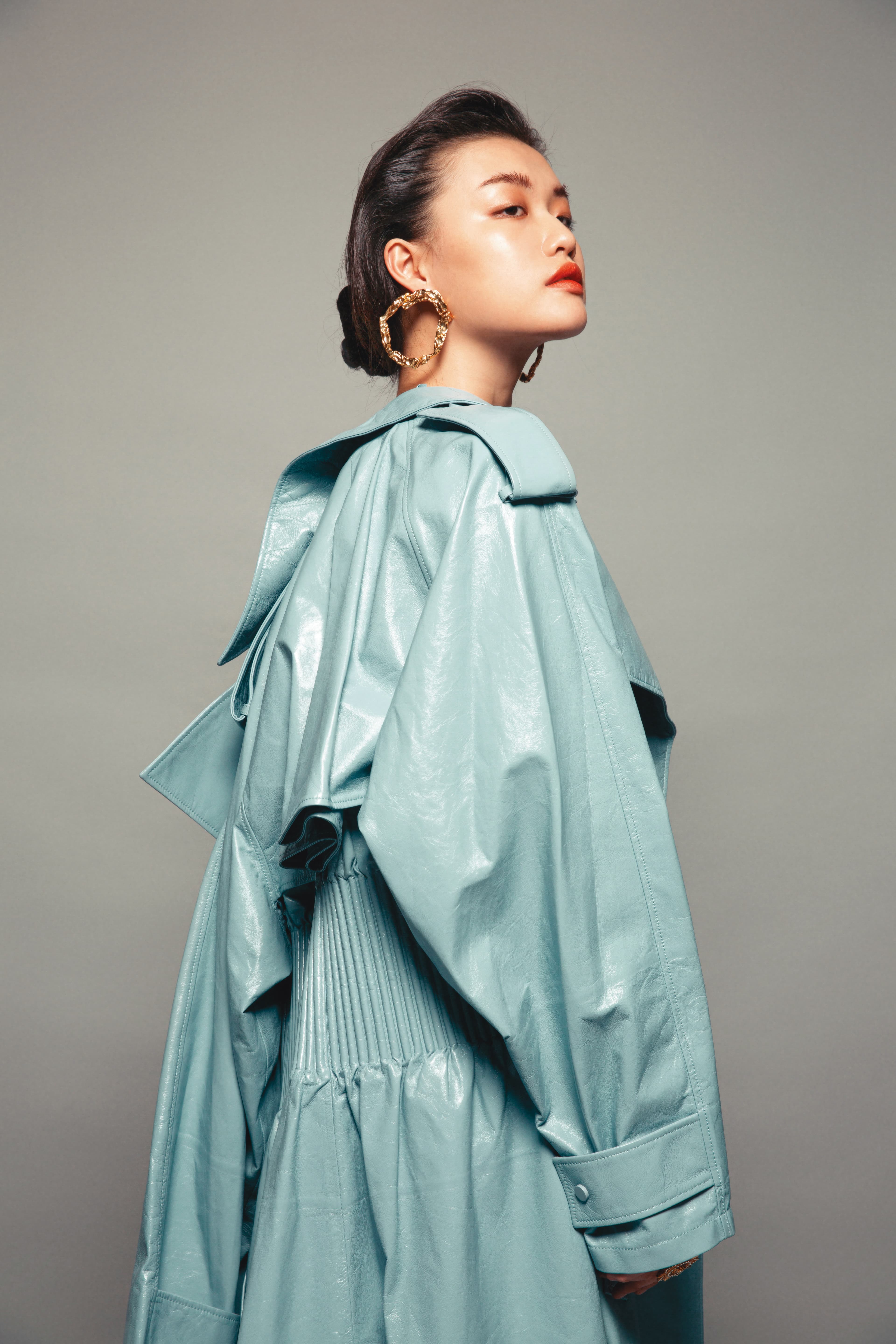 冰雪藍羊皮風衣式大衣 NT$234,800 by Bottega Veneta；Anouck耳環 價格店洽 by Chloé；梅杜莎造型裝飾戒指 NT$15,500 by VERSACE。