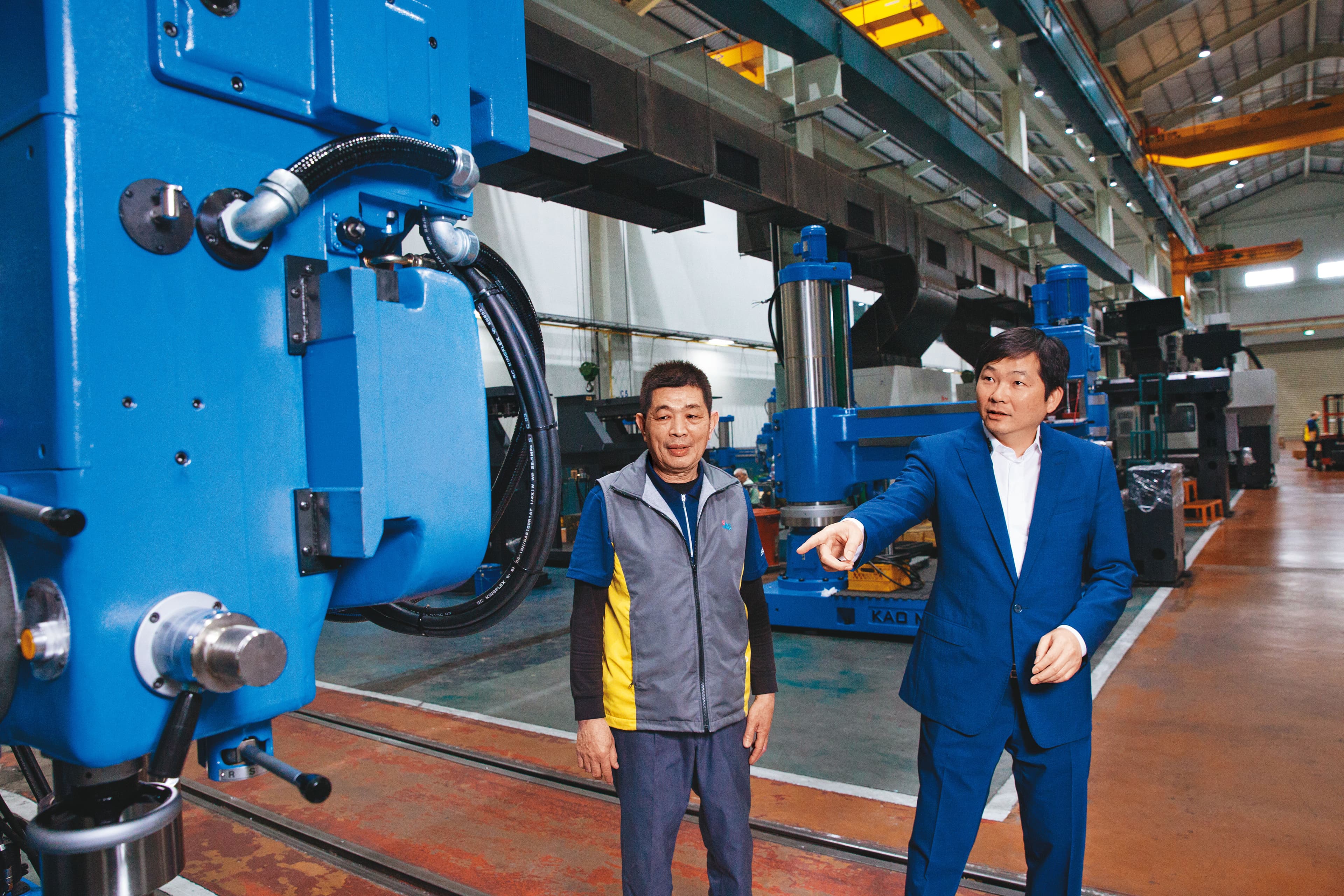 張仕育(右)從小在工廠長大,國中時就被父親叫去學配電、鎖螺絲,對機械設備相當熟稔。