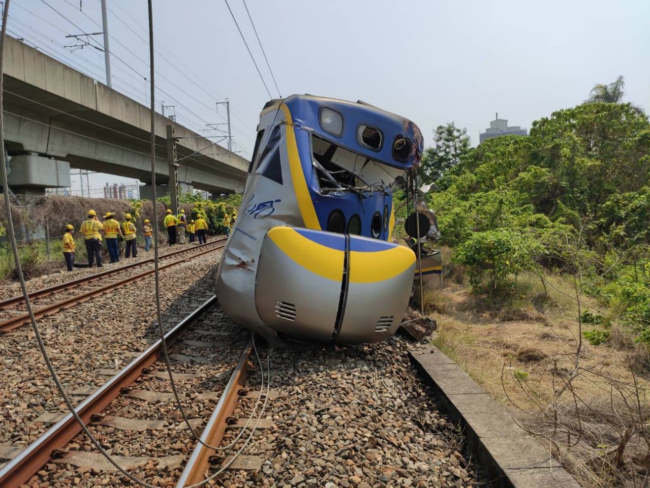 聯結車入侵平交道,區間車撞上導致三節車廂出軌、車頭全毀、人員受傷。(台鐵提供)