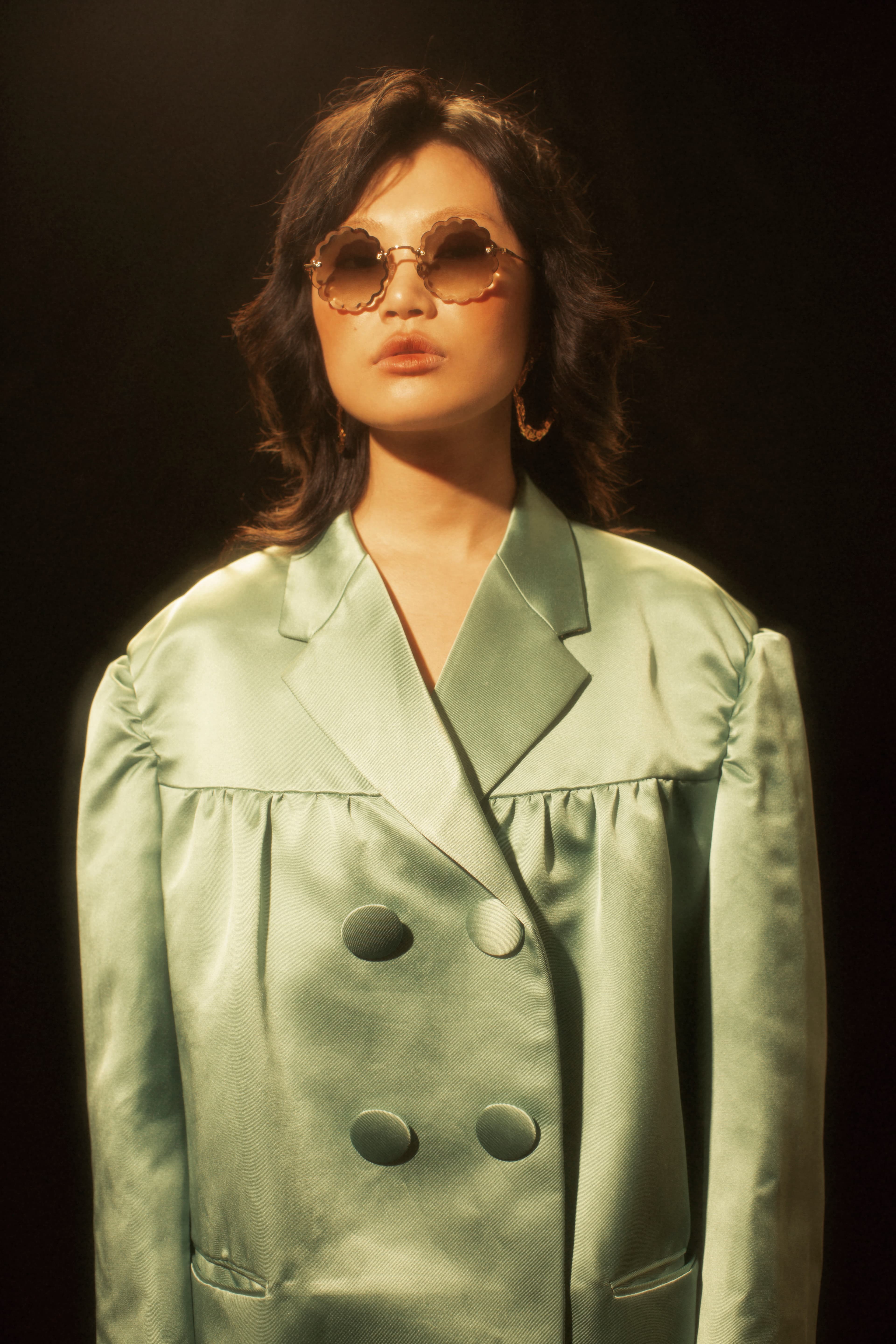 花朵形漸層太陽眼鏡 NT$18,300 by Chloé、金色耳環 價格店洽 by Chloé 、淺綠色oversize外套 NT$14,450 by MIU MIU。