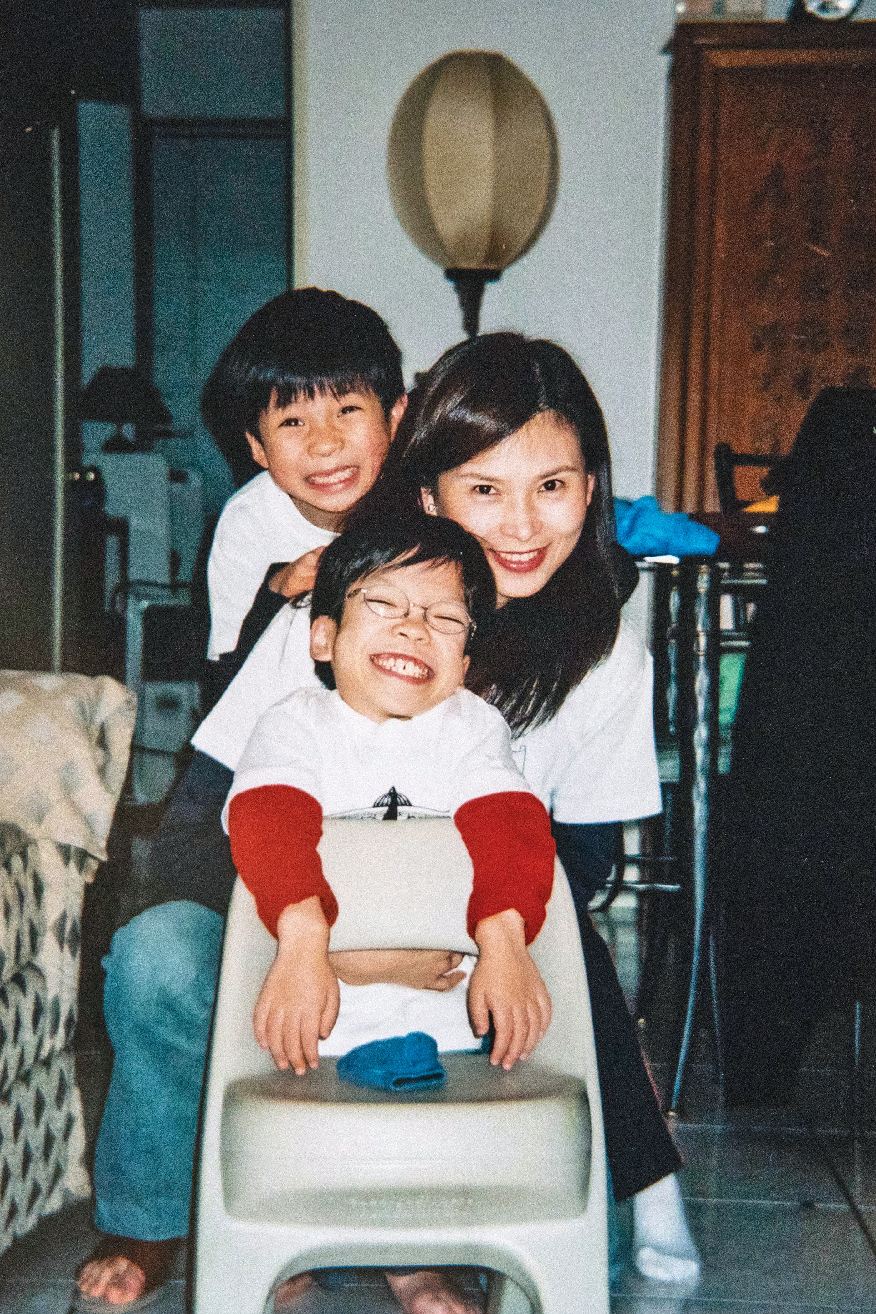 永強8歲時(前)與媽媽歐玲君(中)、弟弟(後)準備外出參加運動會時開心地合照。(歐玲君提供)