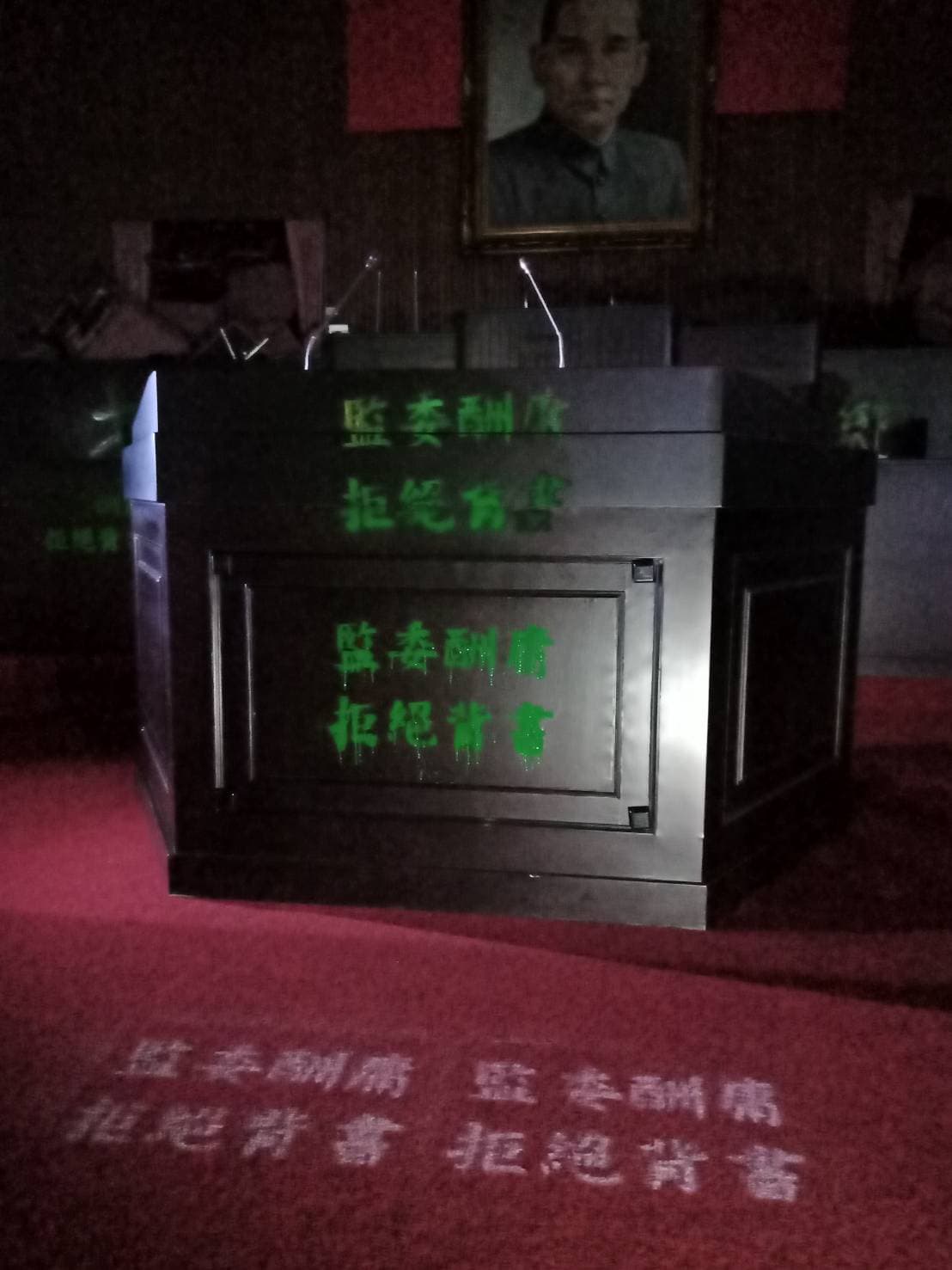 20名藍委今破門佔領議場，在場內噴漆「監委酬庸，拒絕背書」字樣抗議。（國民黨團提供）