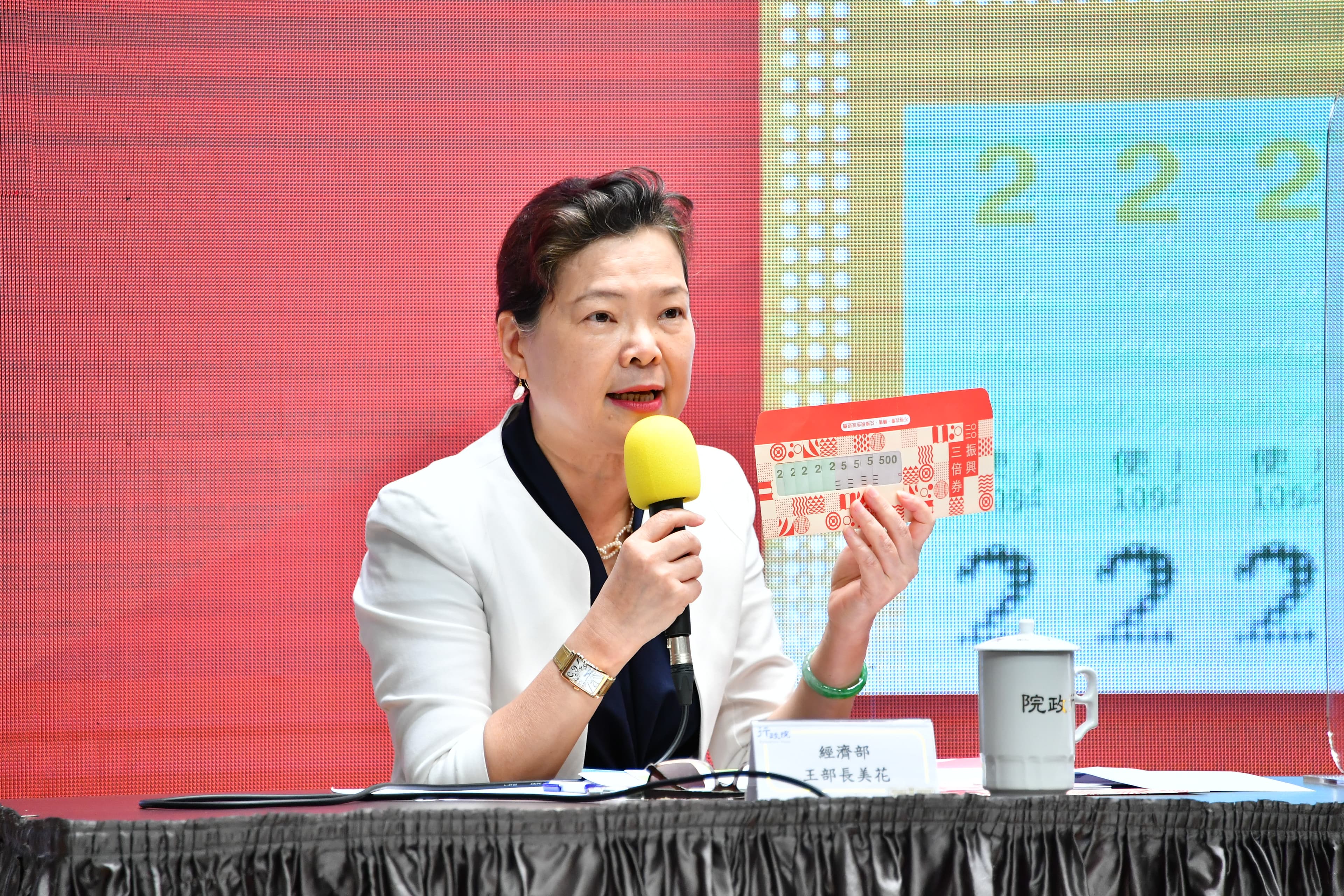 經濟部長王美花介紹三倍券的封套有透明的框,非常精美。(行政院提供)