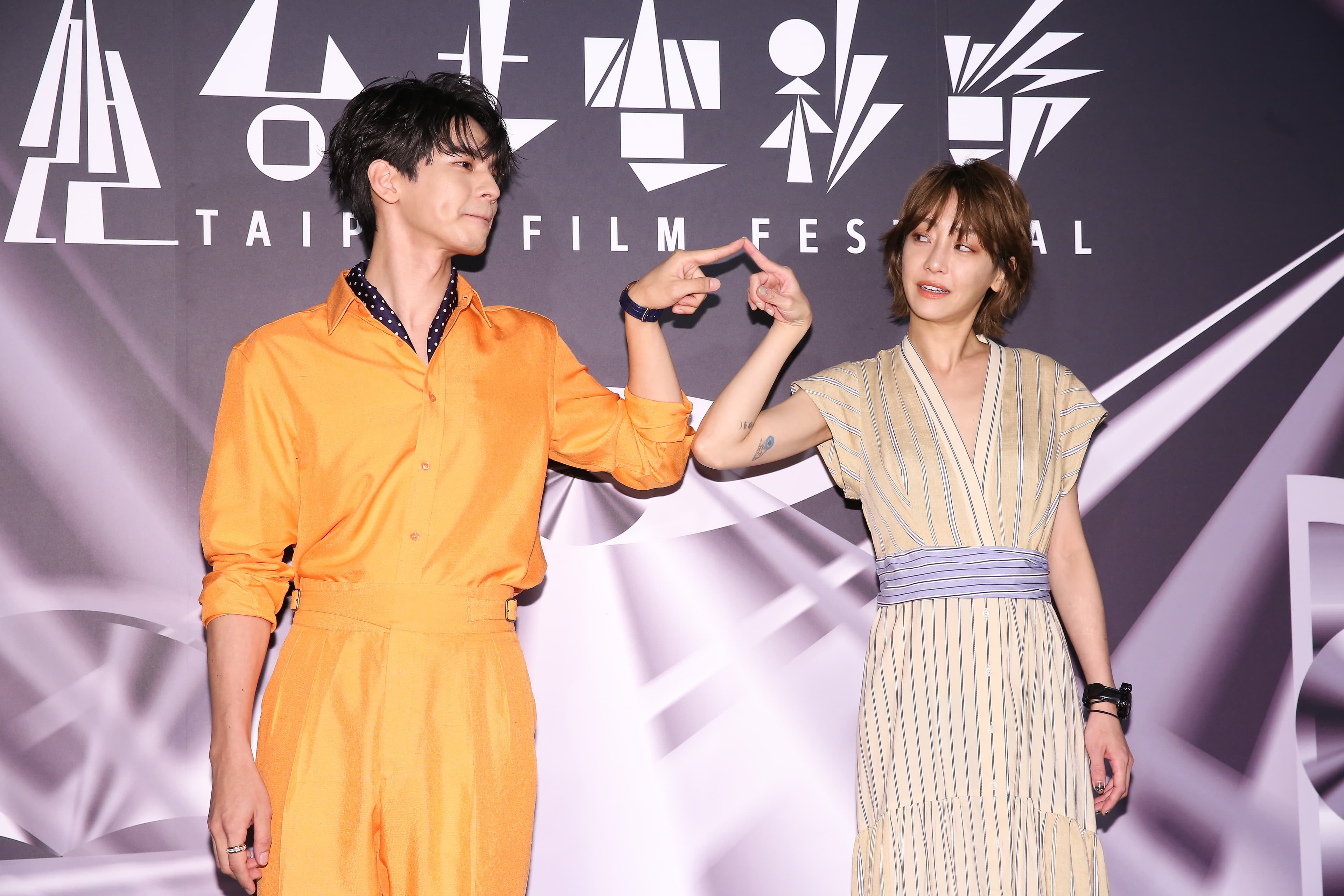 林柏宏(左)、謝欣穎(右)以《怪胎》片中有強迫症患者的身份,舉出手指合影。