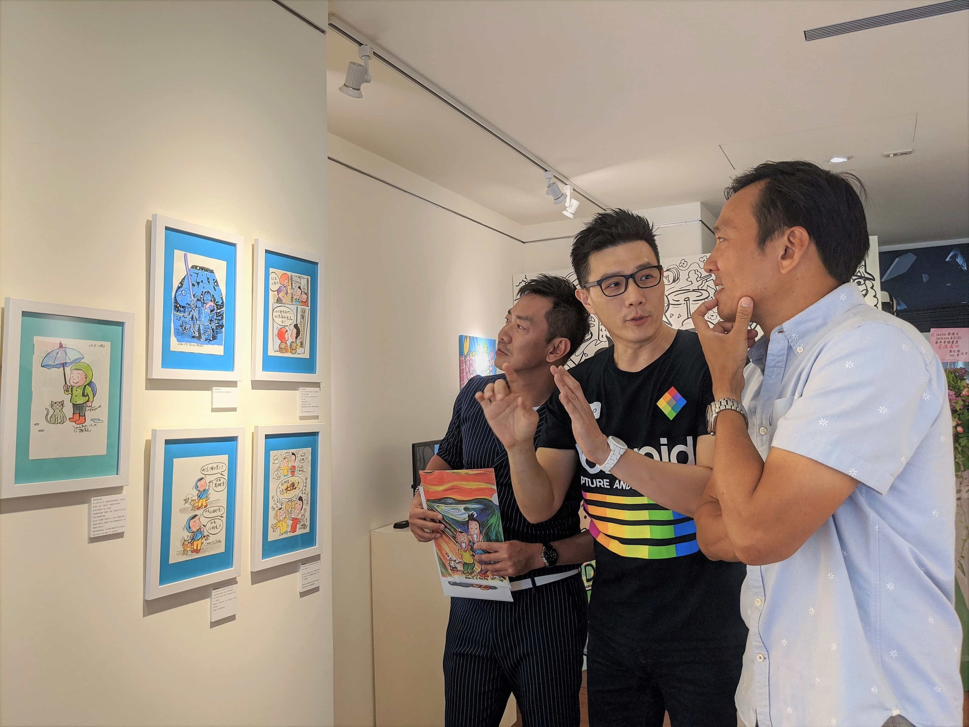 蔣偉文(中)向昔日團員解說畫作。(艾迪昇傳播提供)