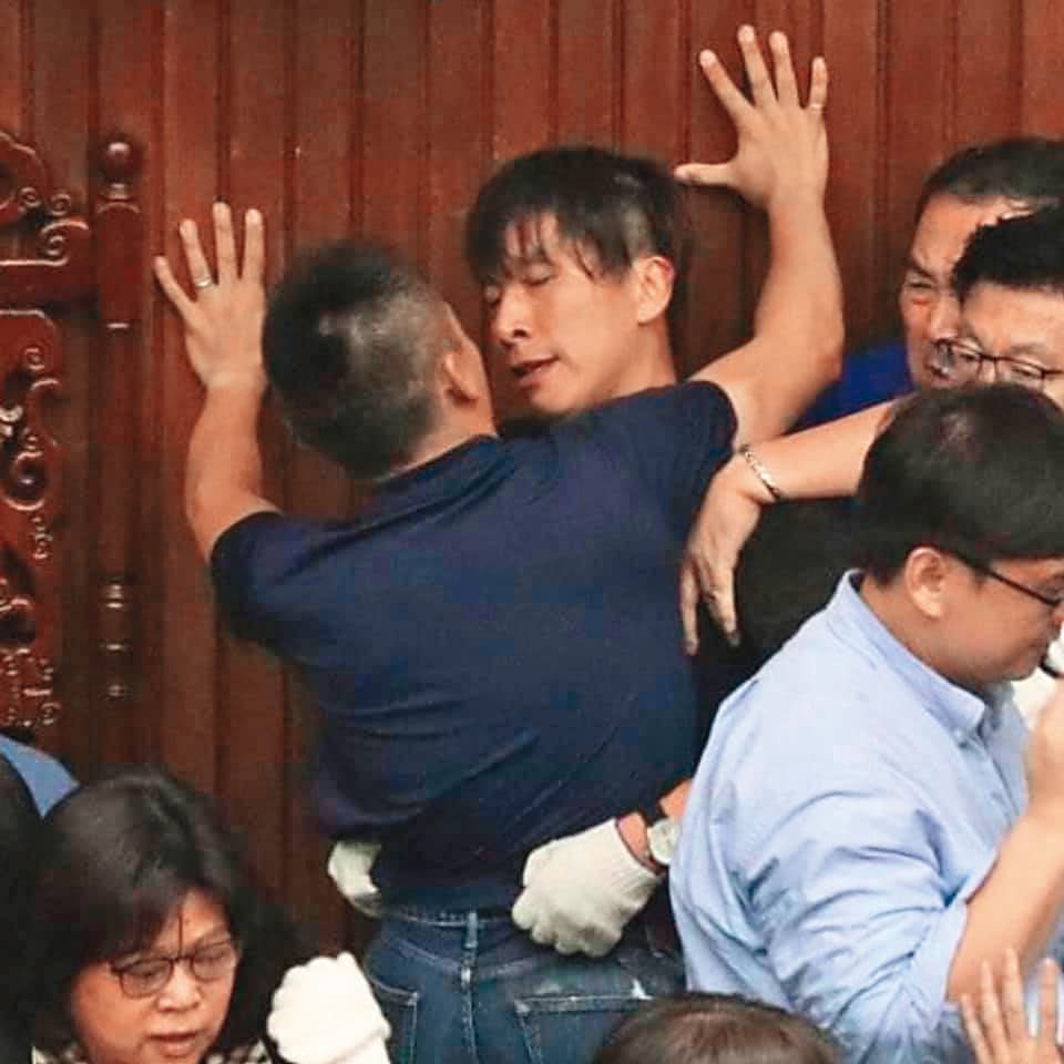 藍綠立委攻防,洪孟楷(前)「壁咚」鍾佳濱(後), 「男」分高下。(翻攝自貓與邪佞的手指臉書)