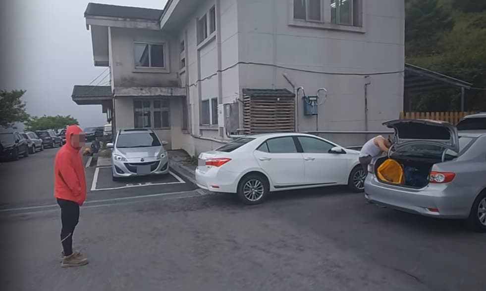 疑似與違停車輛駕駛同行的紅衣山友,在鏡頭前嗆聲。(翻攝自Youtube頻道Kris Loak)