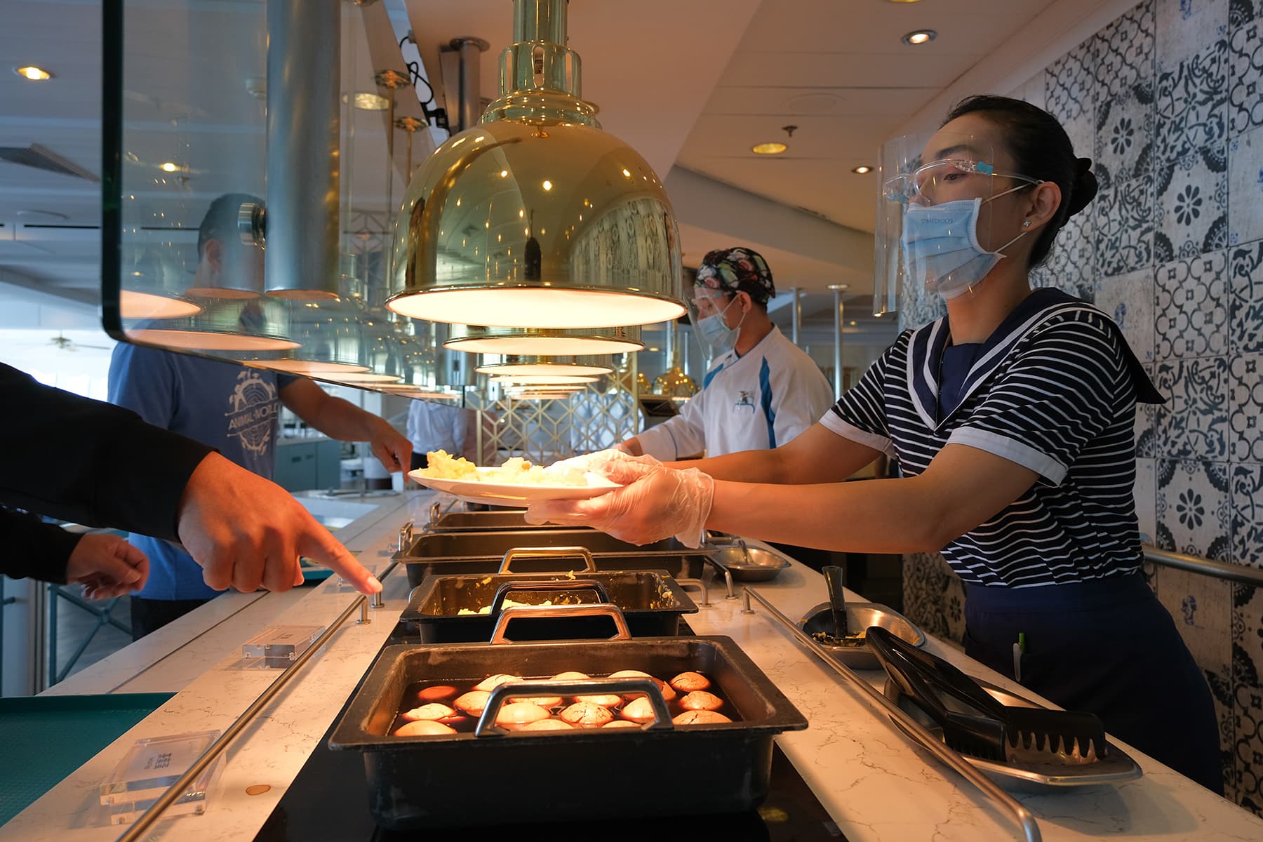 自助餐廳不讓客人自己拿食物，改由服務人員協助夾取。