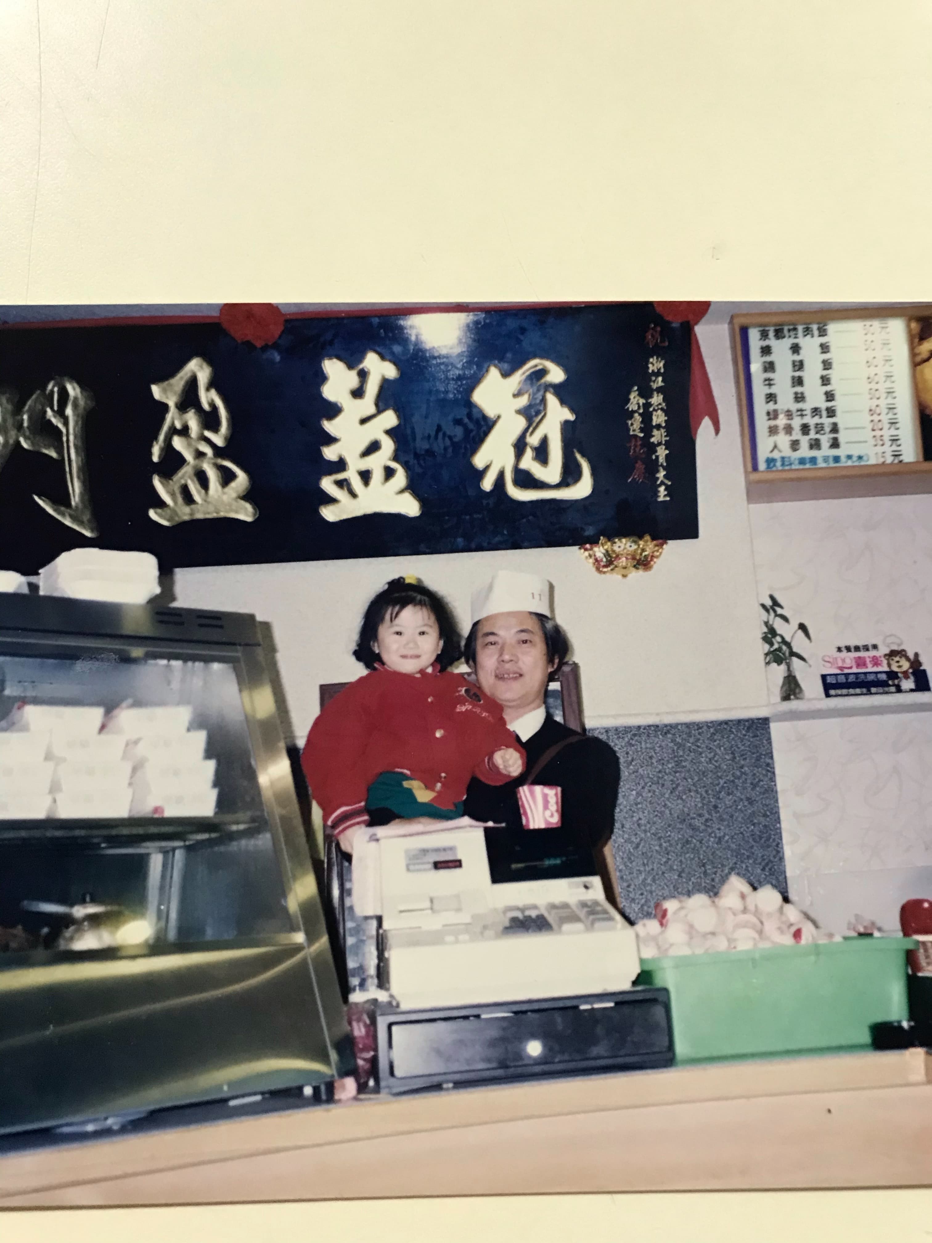簡秋正43年前赴花蓮創業，生意穩定才把兒女接來團圓，圖為他抱著外孫女巡店。（簡鸝鴻提供）