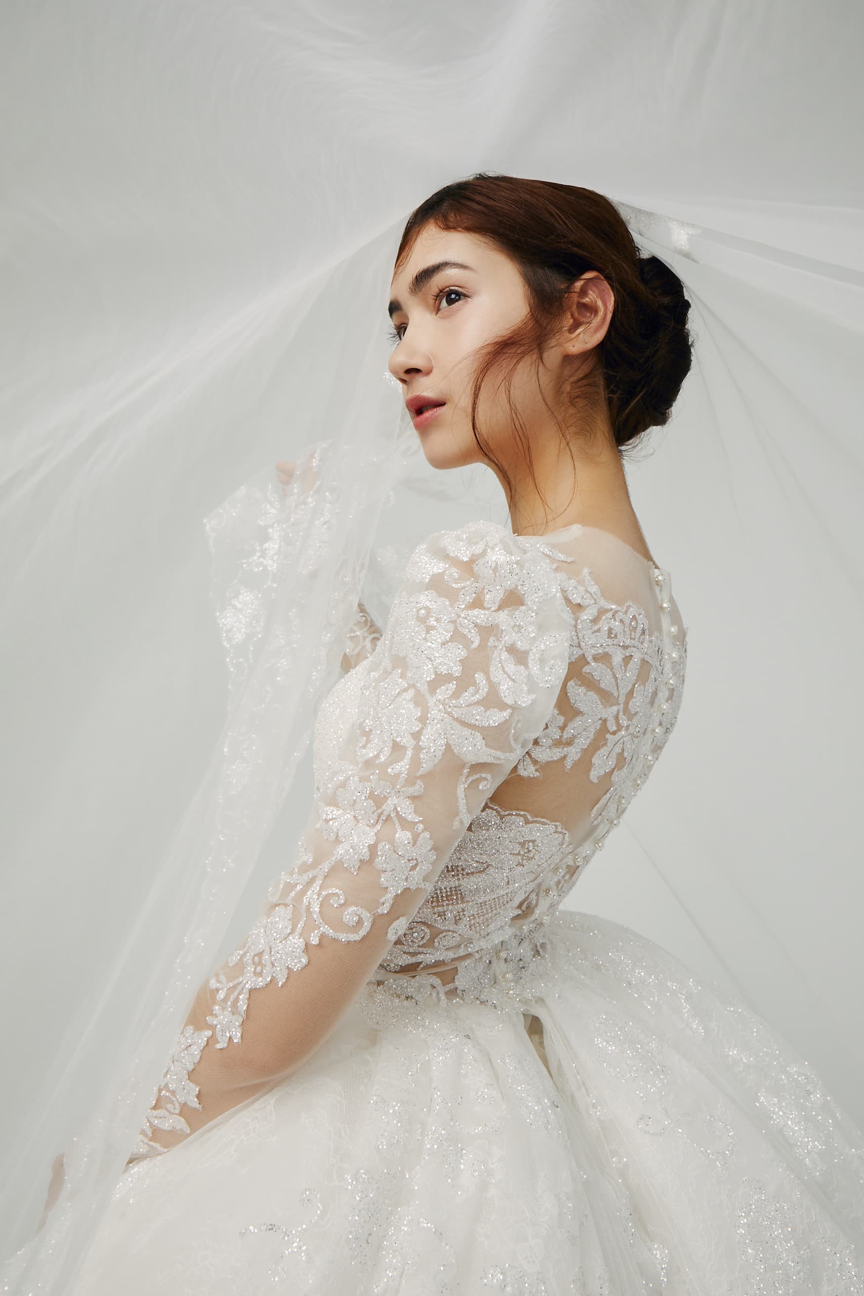 「Claire」以義大利亮粉蕾絲製成的長袖白紗微澎公主袖型,甜美的蕾絲花紋置於最上層包覆著雪白肌膚,若隱若現的設計不僅修飾手臂線條,和澎裙搭配盡顯公主氣質。(SophiaRitz蘇菲雅婚紗提供)