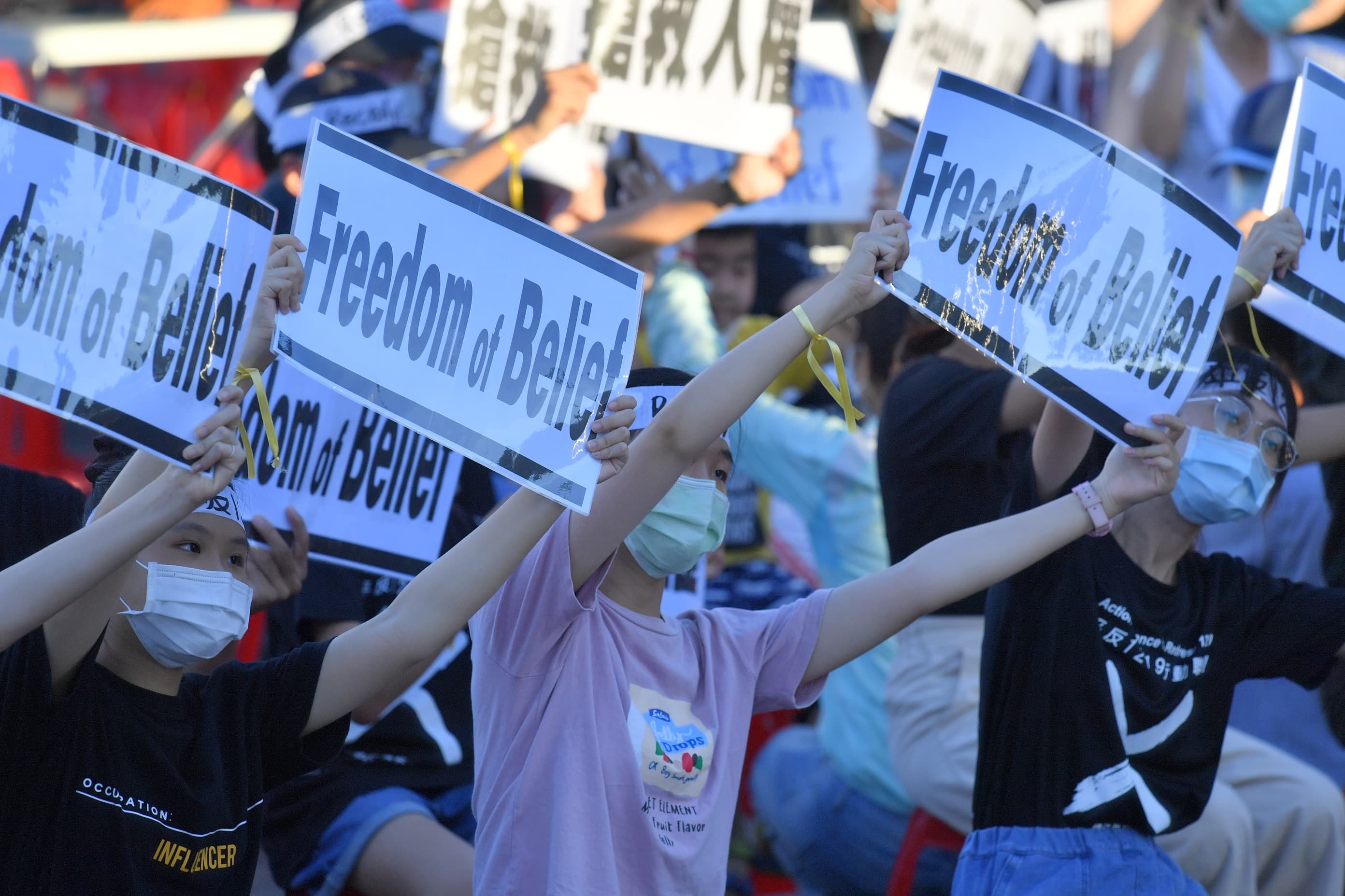 青少年總統府前舉抗議牌,要請總統救救人民。(太極門提供)