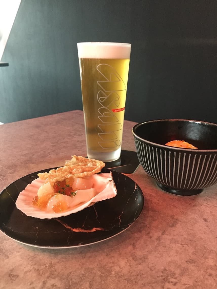「雞皮干貝」鮮脆(前,120元/份)、「酒粕起司鮮蝦」鮮鹹(右後,220元/份),和清爽經典黃啤,很合拍。