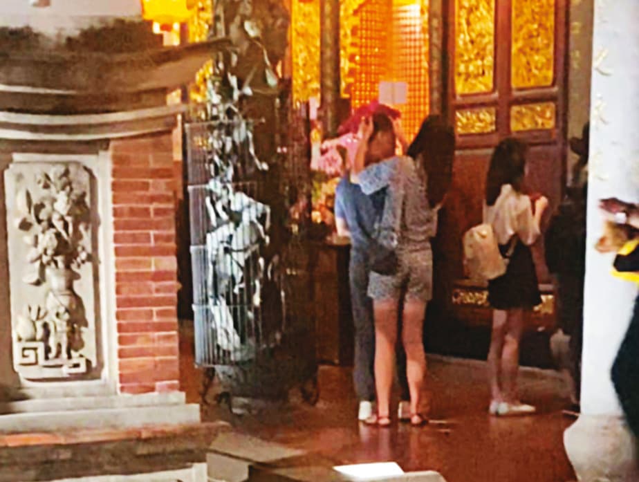 08/07 20:19 A女(中)將程昌興(左)伺候得無微不至,拜拜時還會用衛生紙幫程擦汗。