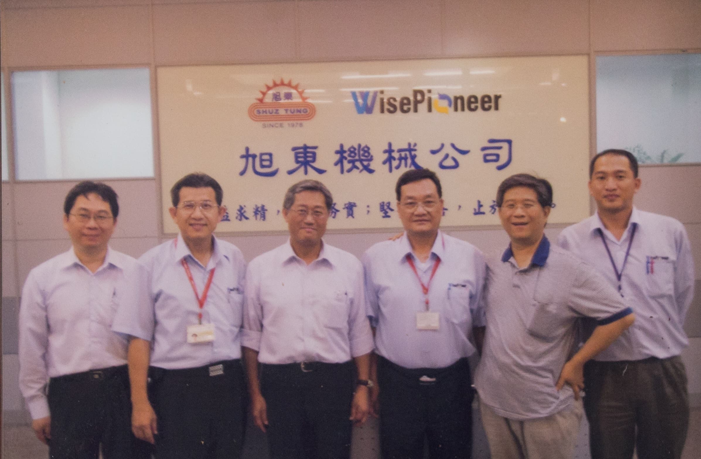 友達光電前董事長李焜耀(左3)是提攜旭東機械進入光電產業的貴人,莊添財(右3)飲水思源,辦公室高掛2人的合照。
