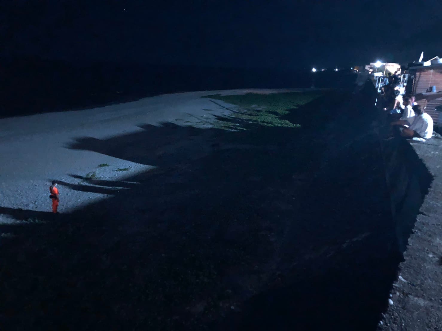 海巡人員在距離綠蠵龜約10公尺處進行戒護,並向周遭遊客柔性勸導切勿大聲喧嘩及開啟任何燈源等事項,以維持現場環境使綠蠵龜能順利產卵。(海巡署提供)