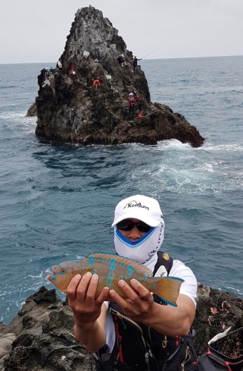 磯釣高手展示剛釣到的鸚哥魚。
