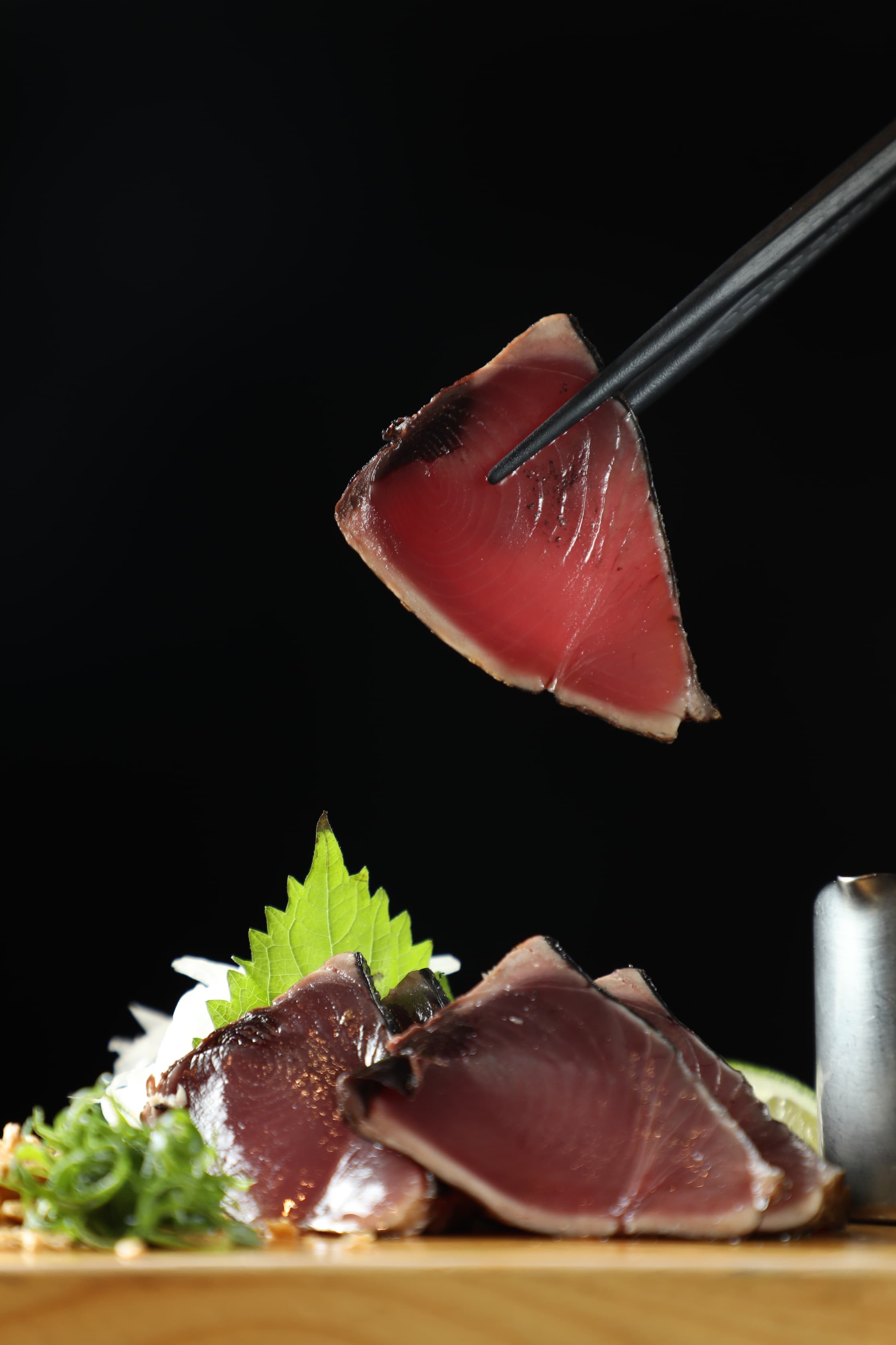 「鰹魚稻草燒」搭配洋蔥、山葵、蒜粉吃，毫無紅肉魚常見的腥氣，選料確實用心。（250元／份）