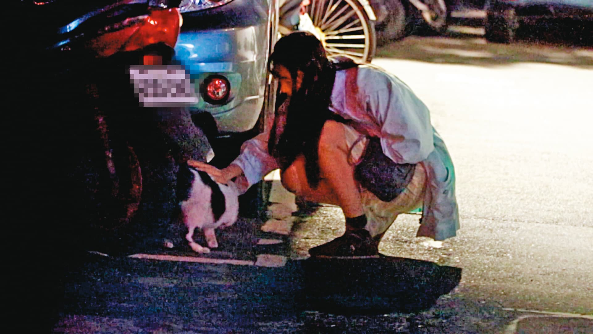01:43 王若琳進家門前,蹲在路邊車子旁撫摸野貓。