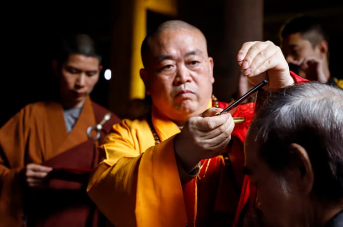 由少林寺方丈釋永信大和尚(中)幫蔡志忠(右)完成剃度儀式。(翻攝自釋永信微博)