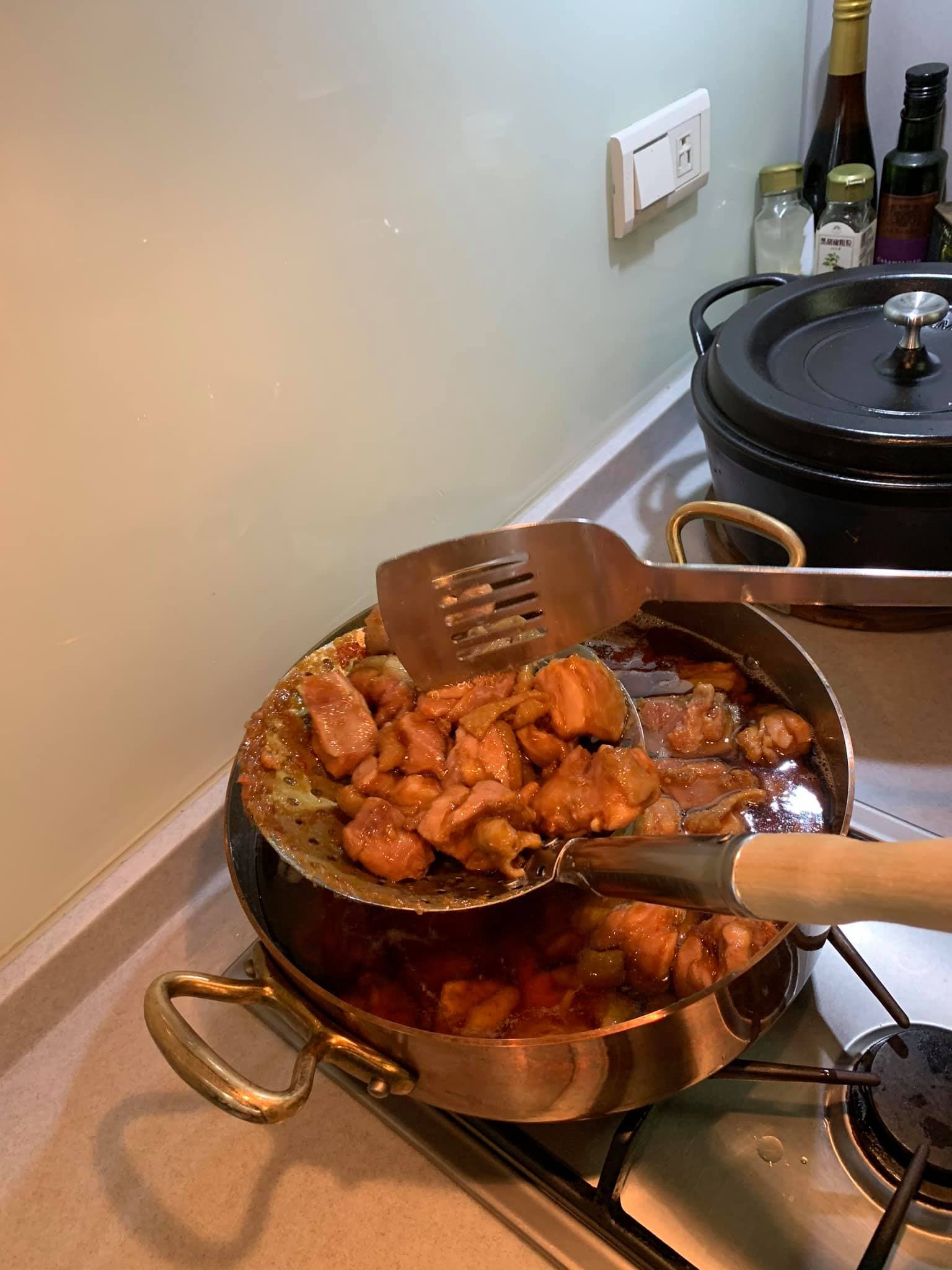 撈起雞塊，用鏟子敲鬆肉塊。