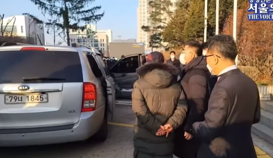 趙斗淳將沒上銬的雙手背在後背,該動作即使鞠躬道歉也未停下。(翻攝自서울의 소리 The Voice of Seoul YouTube頻道)